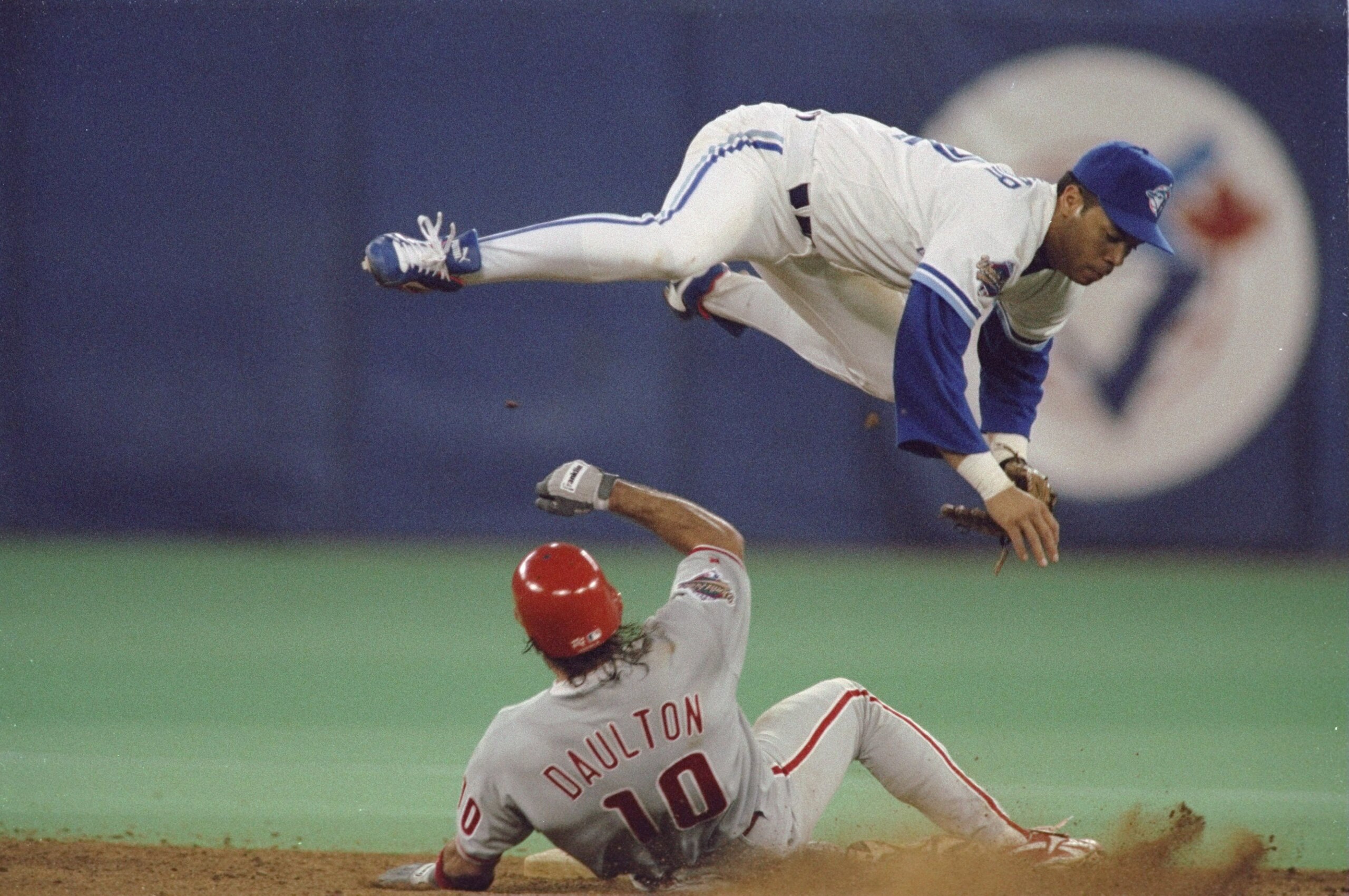 17 Oct 1993:  Second baseman Roberto Alomar of the Toronto Blue Jays jumps over Phillies Catcher Darren Daulton #10 sliding into second base to avoid the collision after throwing the ball to first base during the 1993 World Series Game 2 against the Phila