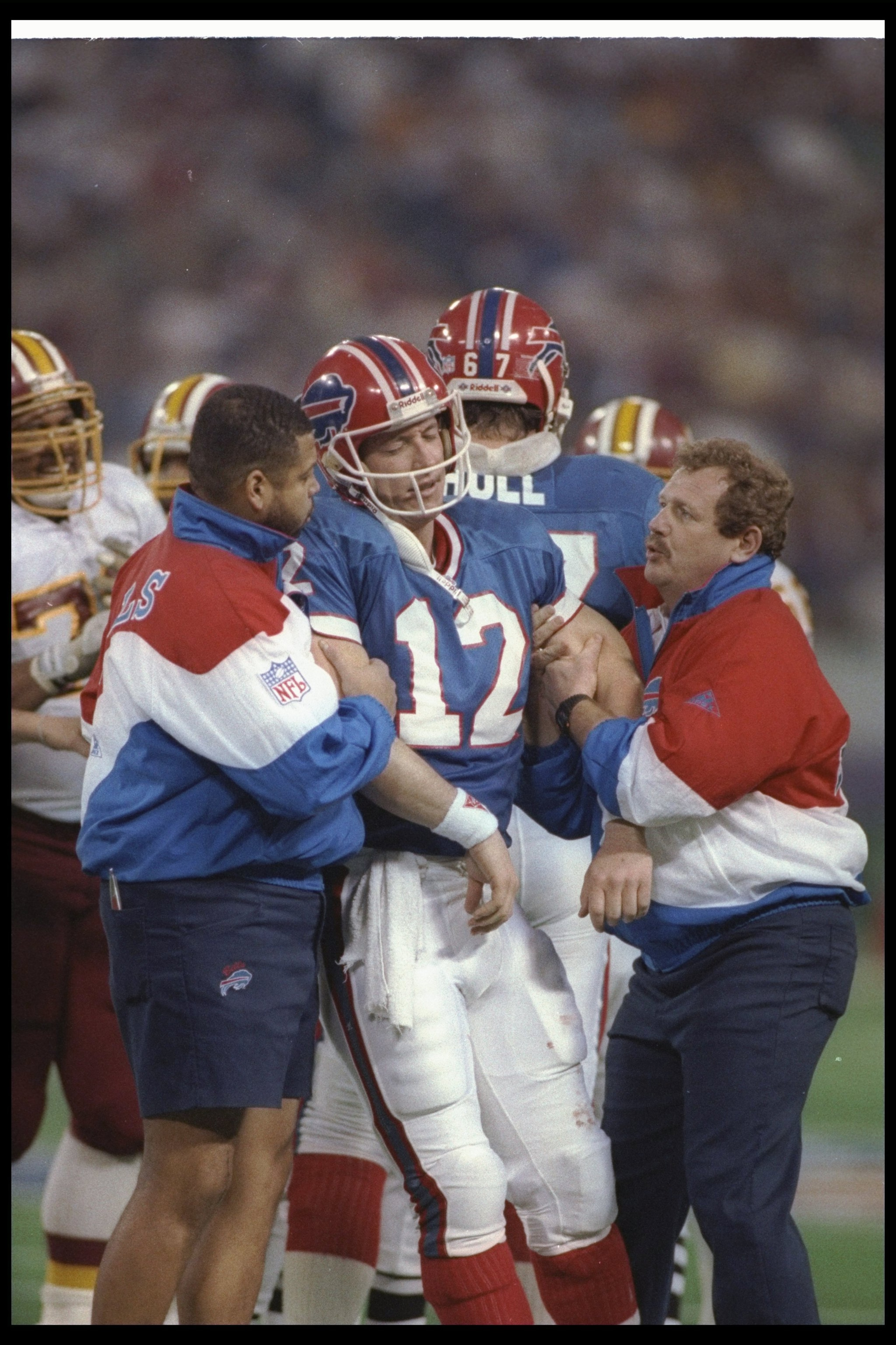 26 Jan 1992:  Quarterback Jim Kelly of the Buffalo Bills is helped off the field during Super Bowl XXVI against the Washington Redskins at the Hubert H. Humphrey Metrodome in Minneapolis, Minnesota.  The Redskins won the game, 37-24. Mandatory Credit: Ric