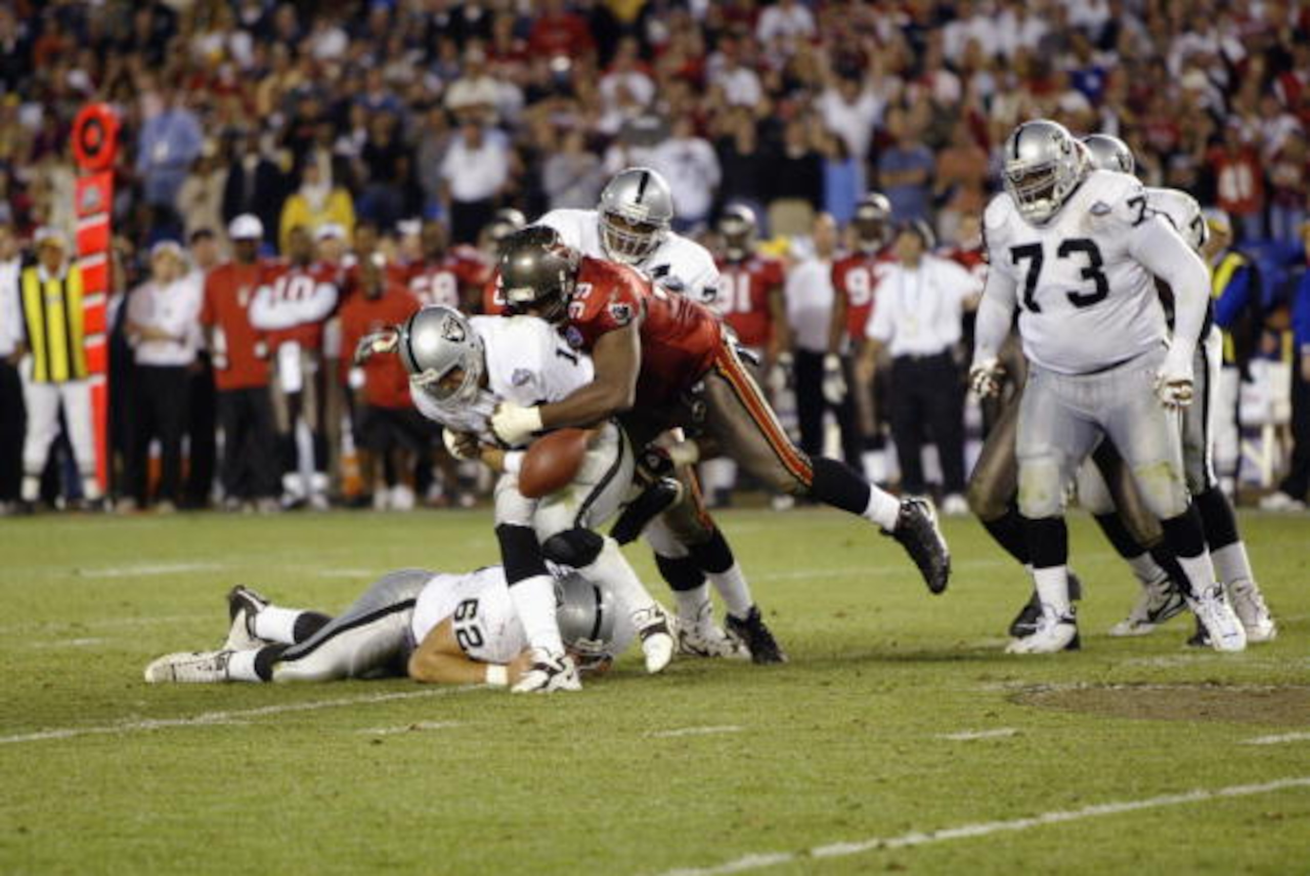 SAN DIEGO - JANUARY 26:  Quarterback Rich Gannon #12 of the Oakland Raiders fumbles the ball after being hit and sacked for a nine yard loss by Warren Sapp #99 of the Tampa Bay Buccaneers on the Oakland 29 yard line at 2:00 of the fourth quarter of Super