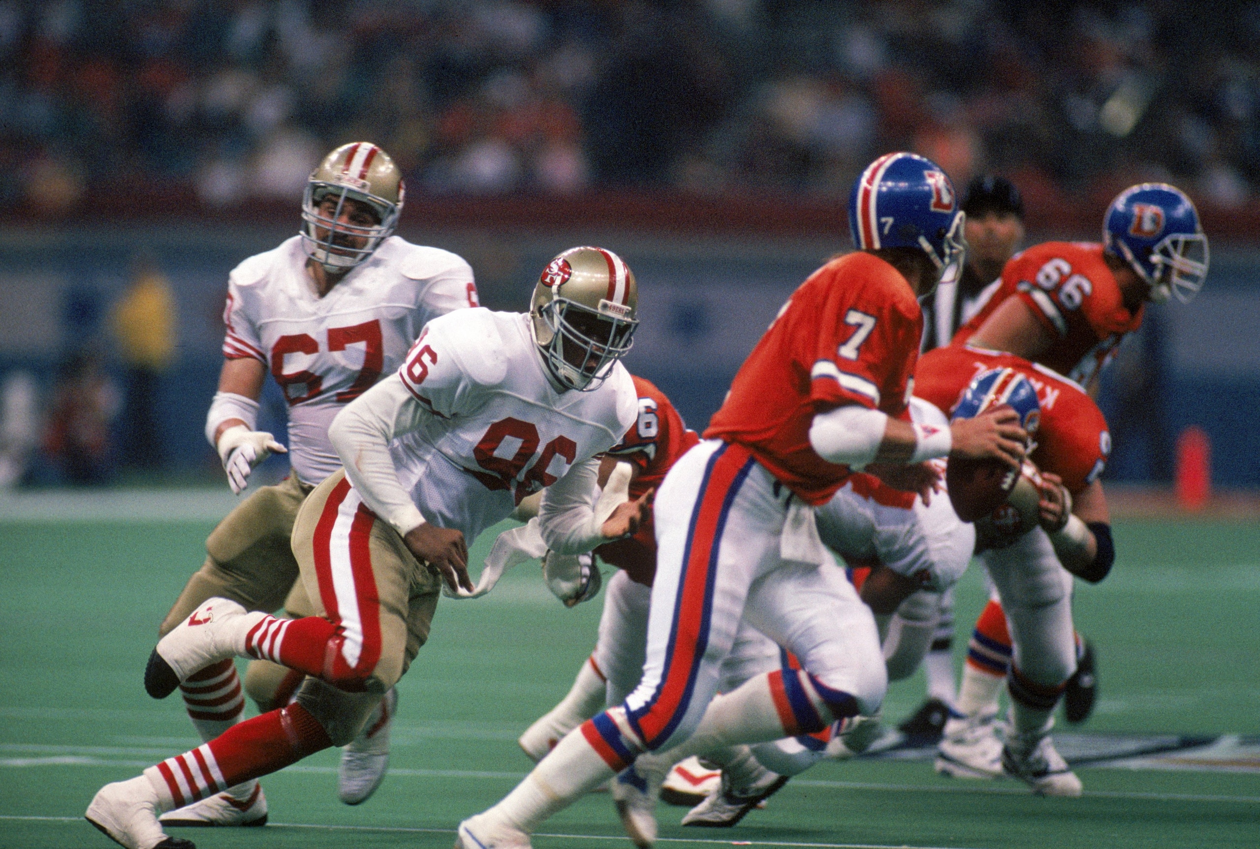 NEW ORLEANS - JANUARY 28:  Defensive end Daniel Stubbs #96 of the San Francisco 49ers pursues Denver Broncos quarterback John Elway #7 in Super Bowl XXIV at Louisiana Superdome on January 28, 1990 in New Orleans, Louisiana.  The 49ers won 55-10.  (Photo b