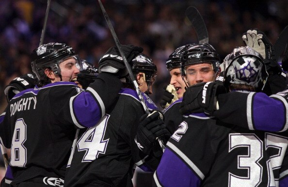 LOS ANGELES, CA - JANUARY 26:  (L-R)Drew Doughty #8, Ryan Smyth #94, Kyle Clifford #13 and Alec Martinez #53 and goaltender Jonathan Quick #32 of the Los Angeles Kings celebrate after defeating the San Jose Sharks 3-2 in shootout overtime at Staples Cente