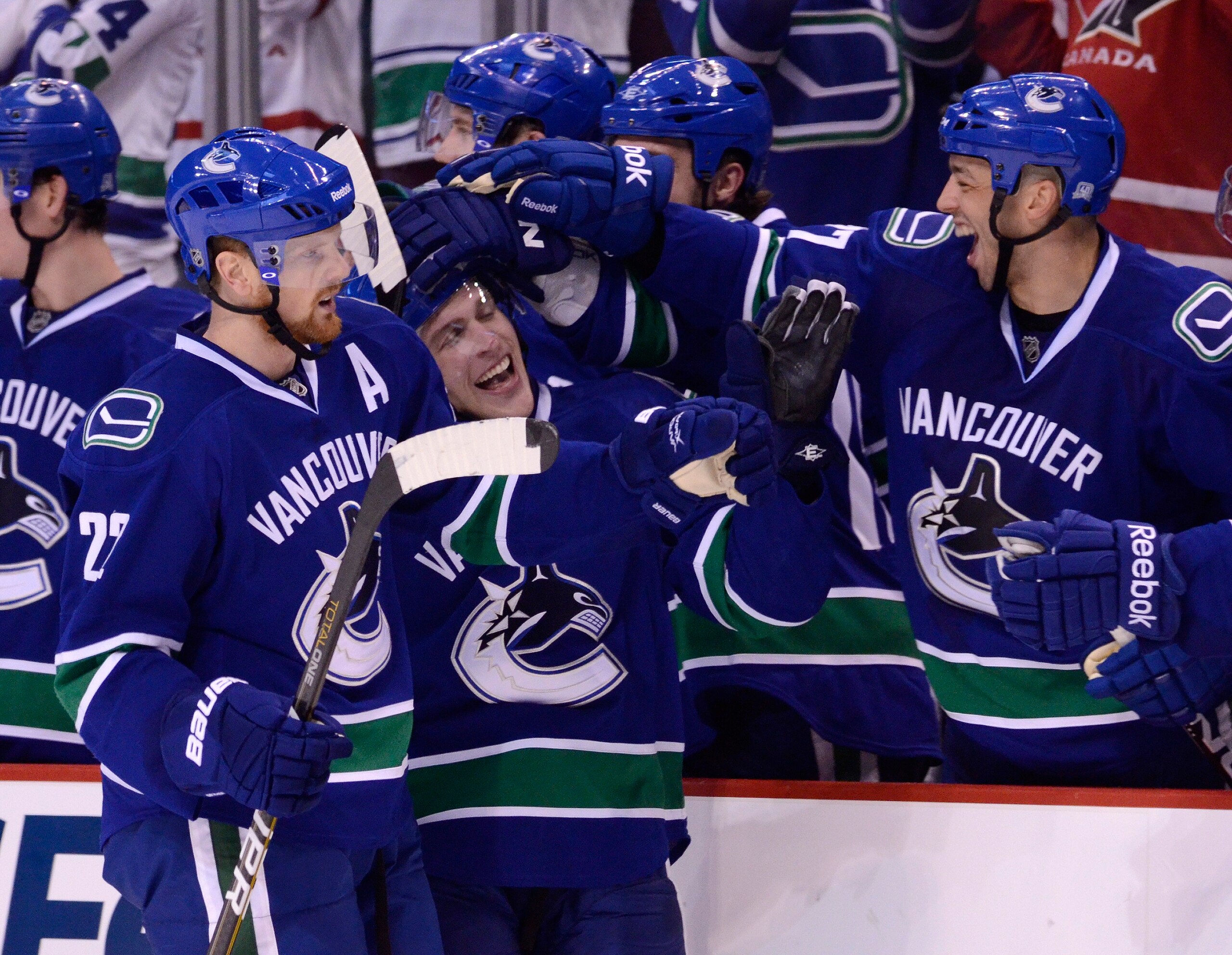 VANCOUVER, CANADA - JANUARY 26: Lee Sweatt #57 of the Vancouver Canucks is congratulated by Daniel Sedin #22 and Manny Malhotra #27 after scoring his first goal in the NHL against the Nashville Predators during the third period in NHL action on January 26
