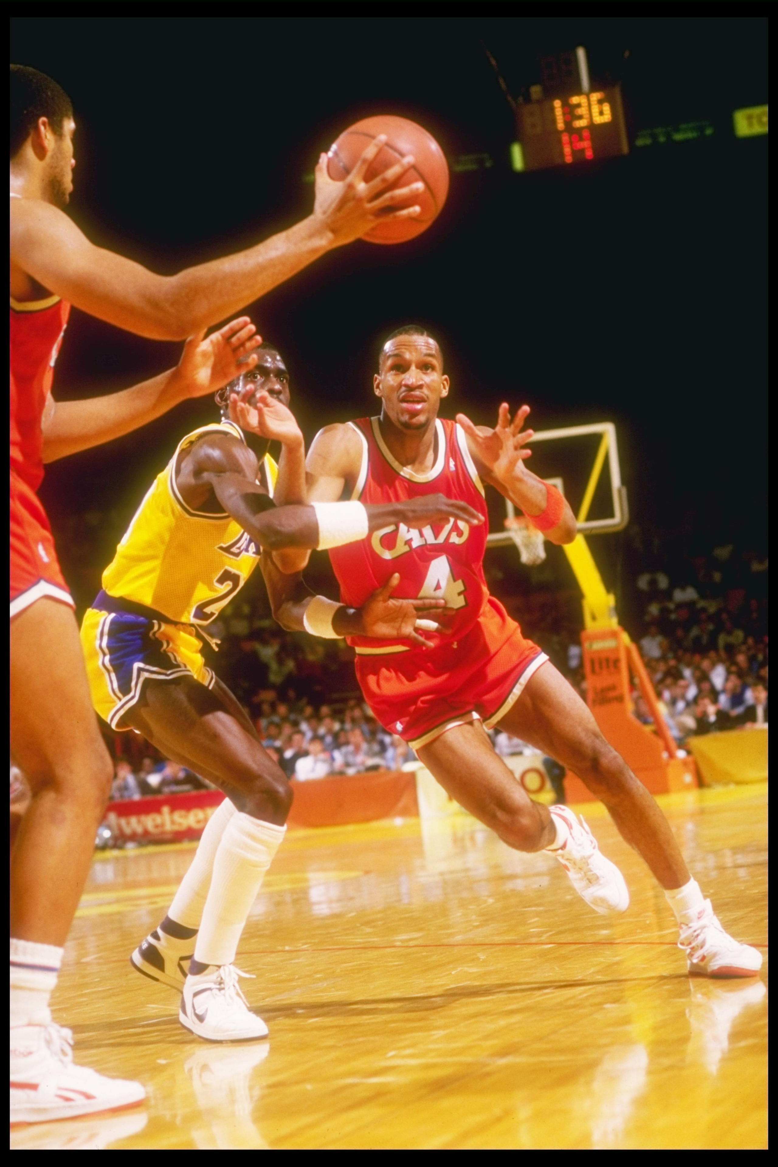 1986-1987:  Center Brad Daugherty (left) of the Cleveland Cavaliers makes a pass to team player guard  Ron Harper over the defense of the Los Angeles Lakers during a game at The Forum in Inglewood, California. Mandatory Credit: Stephen Dunn  /Allsport