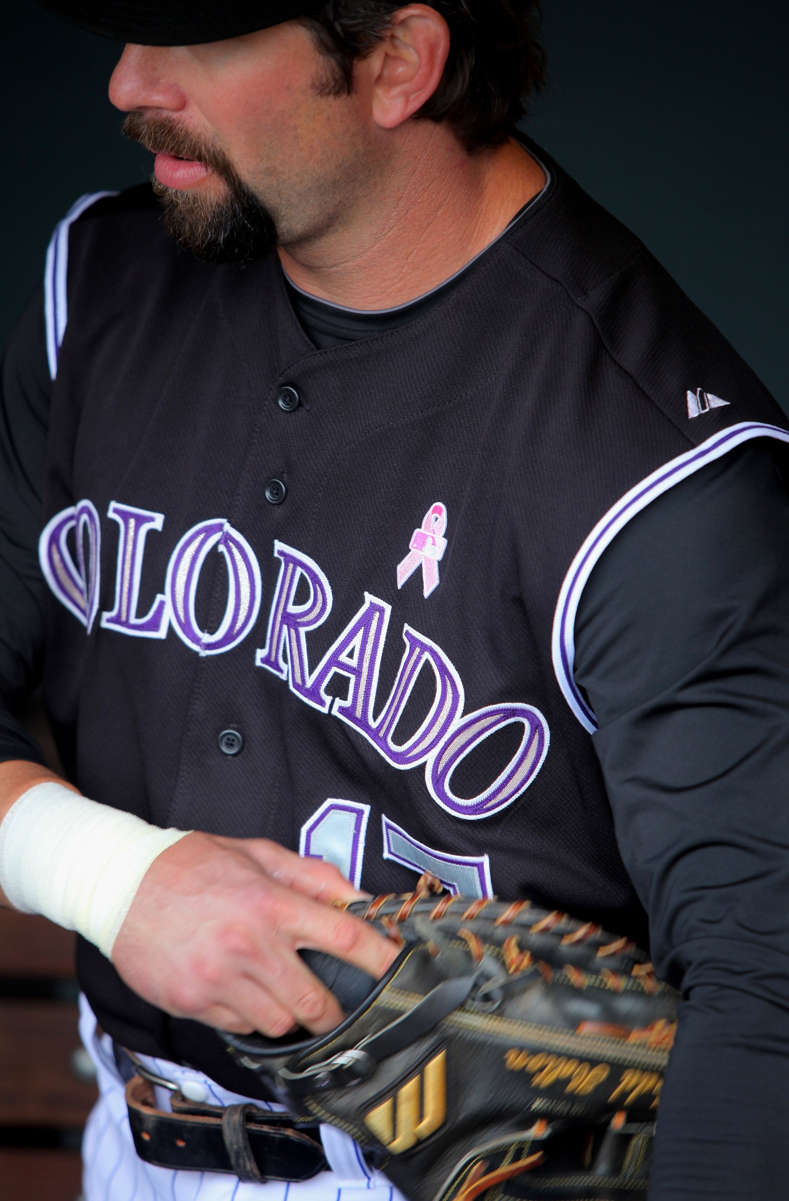 DENVER - MAY 10:  Todd Helton #17 of the Colorado Rockies prepares to take the field as his uniform displays a pink MLB logo and pink ribbon that adorned the players uniforms as part of Major League Baseball's 'Going To Bat Against Breast Cancer' promotio
