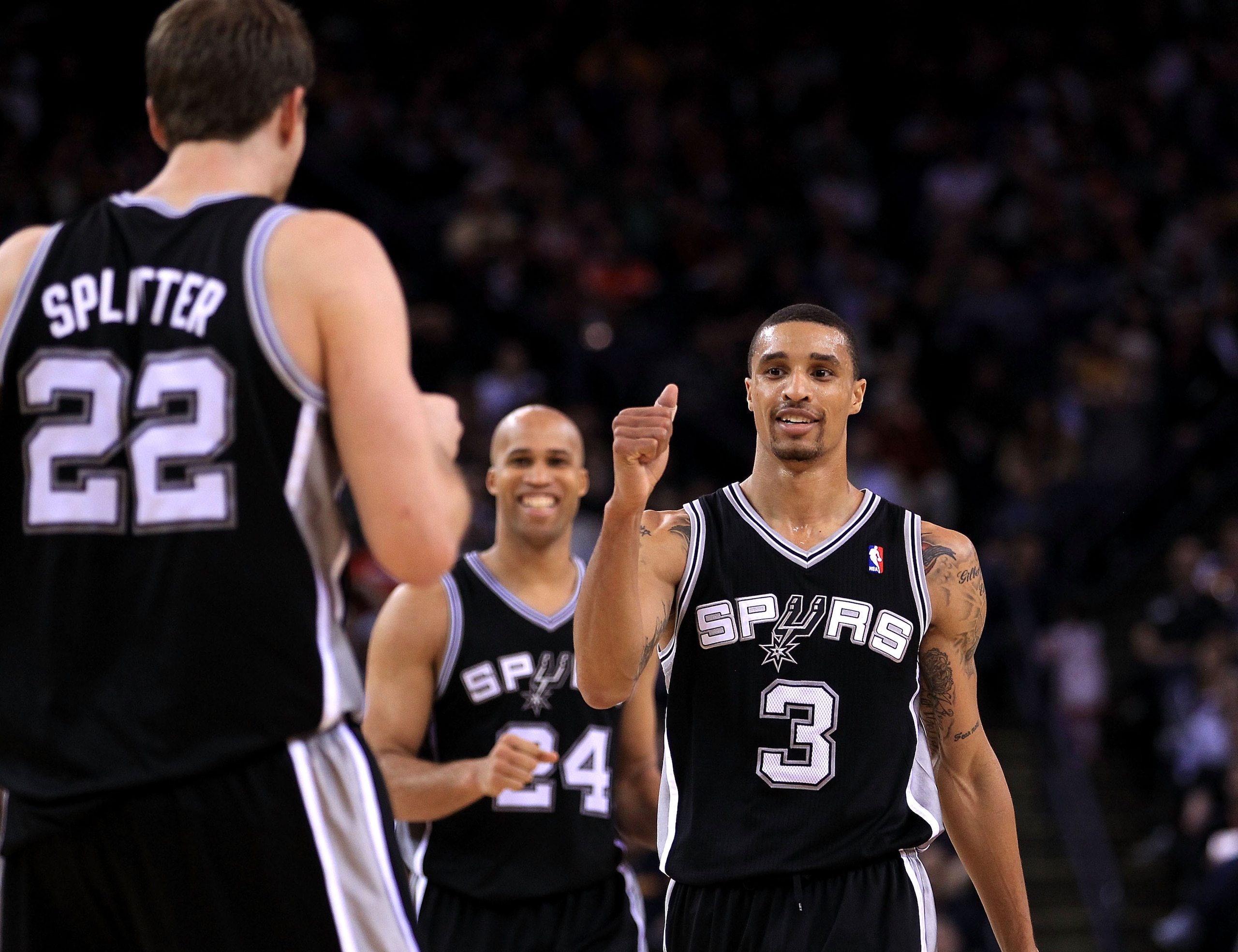 OAKLAND, CA - JANUARY 24:  George Hill #3 and Richard Jefferson #24 of the San Antonio Spurs congratulate Tiago Splitter #22 during their game againsts the Golden State Warriors at Oracle Arena on January 24, 2011 in Oakland, California.  NOTE TO USER: Us