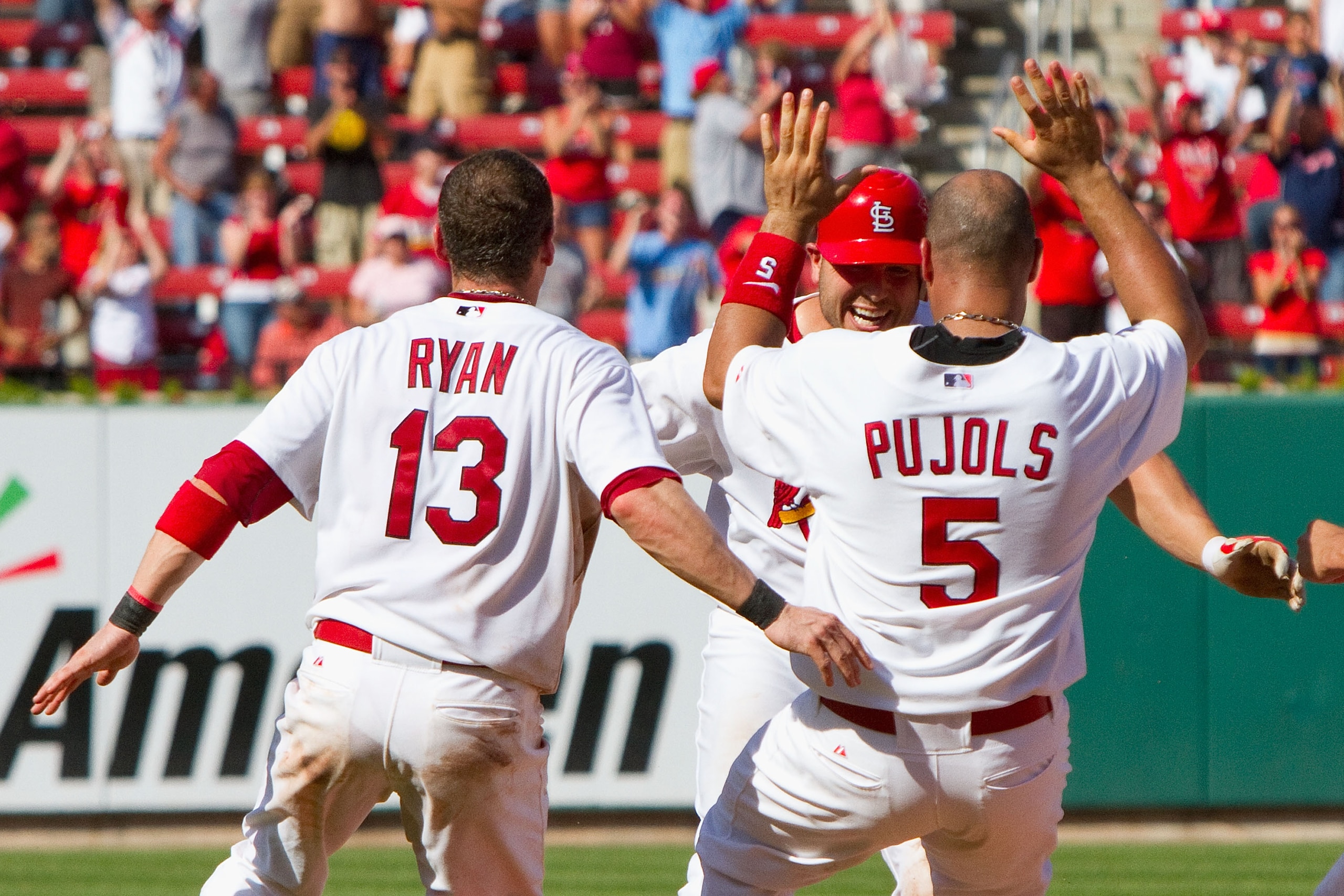 ST. LOUIS - JULY 18: Albert Pujols #5, Brendan Ryan #13, Matt Holliday #7 all of the St. Louis Cardinals celibrate Holliday's walk-off RBI single against the Los Angeles Dodgers at Busch Stadium on July 18, 2010 in St. Louis, Missouri.  The Cardinals beat