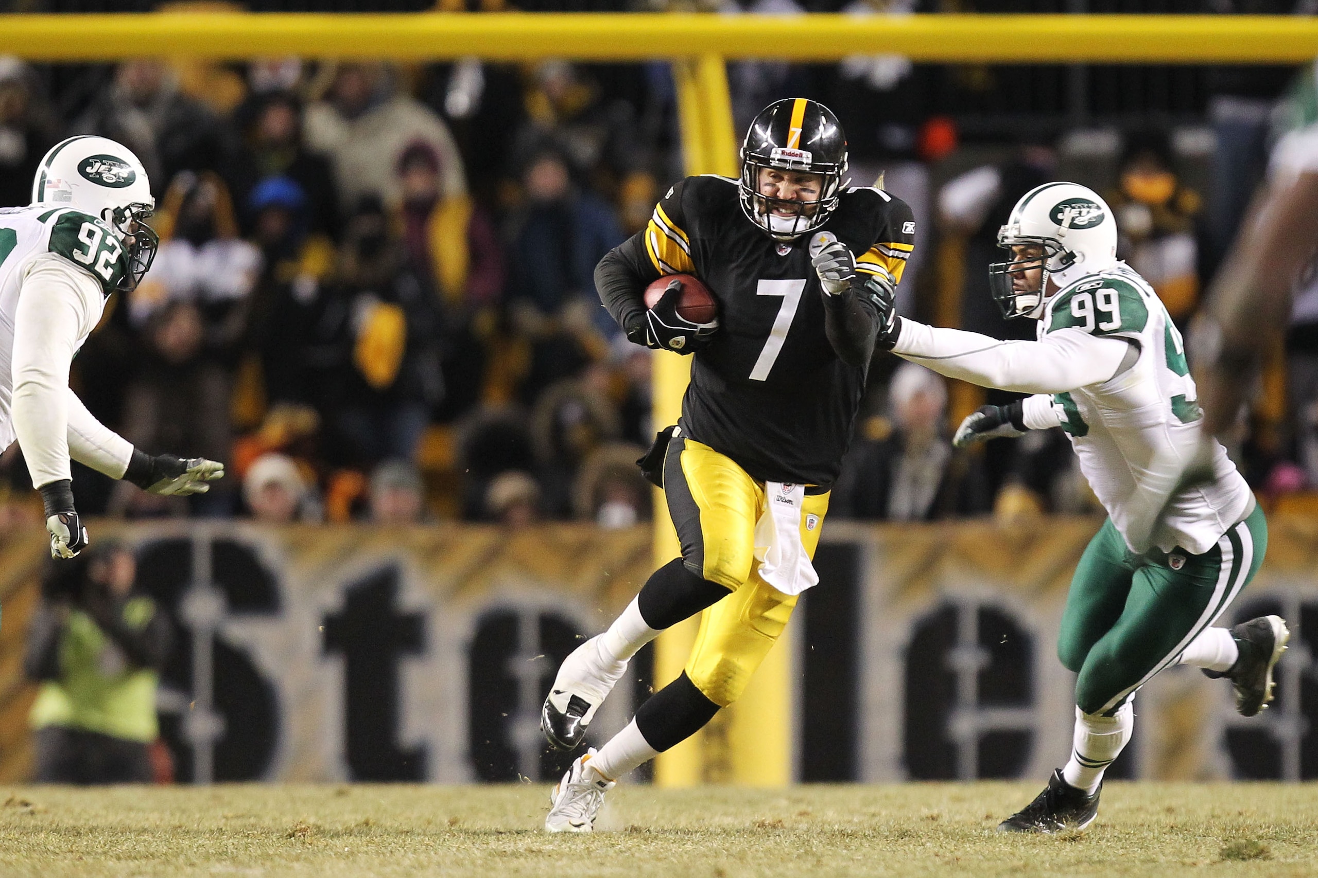 PITTSBURGH, PA - JANUARY 23:  Ben Roethlisberger #7 of the Pittsburgh Steelers runs down field against Jason Taylor #99 of the New York Jets in the 2011 AFC Championship game at Heinz Field on January 23, 2011 in Pittsburgh, Pennsylvania. The Steelers won
