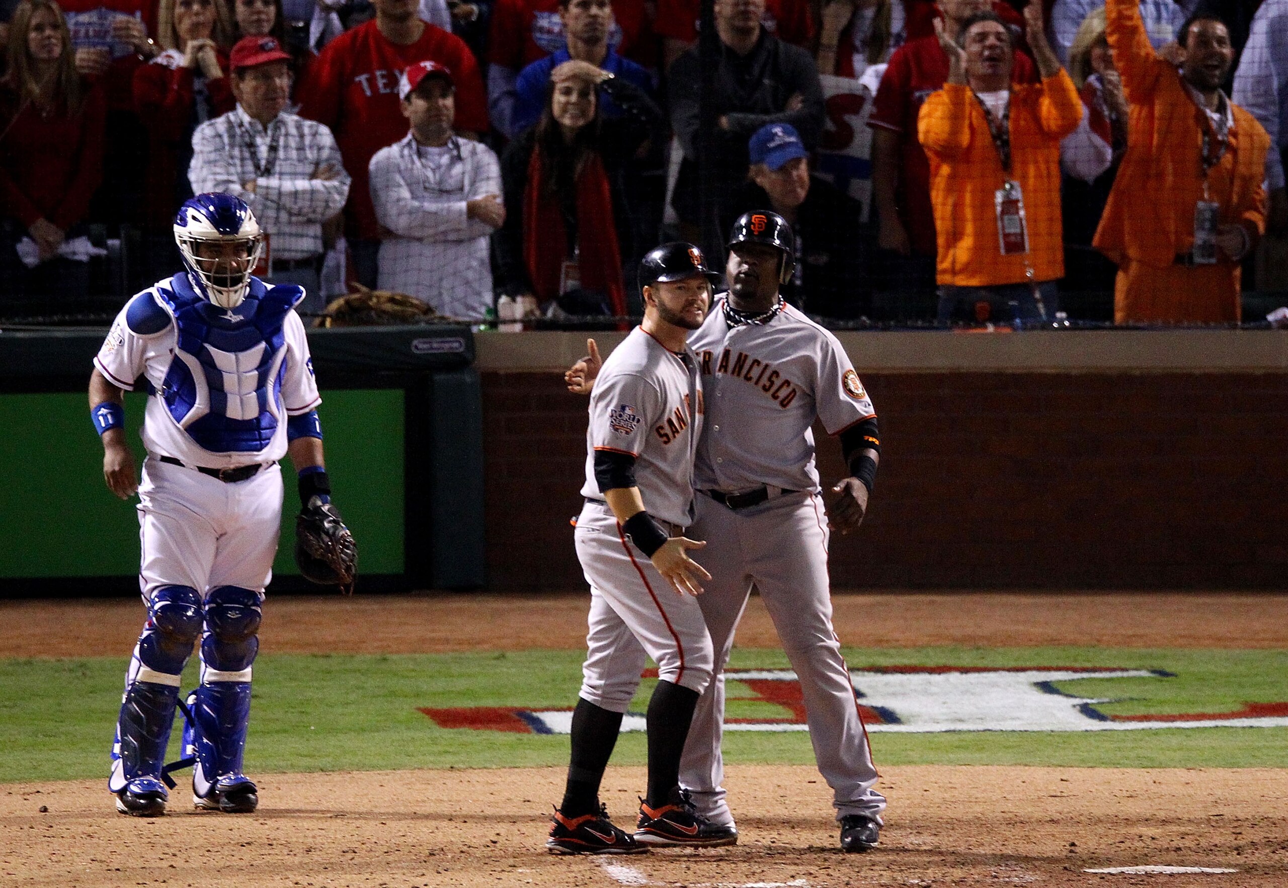 ARLINGTON, TX - NOVEMBER 01:  Cody Ross #13 and Juan Uribe #5 of the San Francisco Giants celebrate scoring off of a homer to centerfield by teammate Edgar Renteria #16 (not pictured) while catcher Bengie Molina #11 of the Texas Rangers looks on in the to