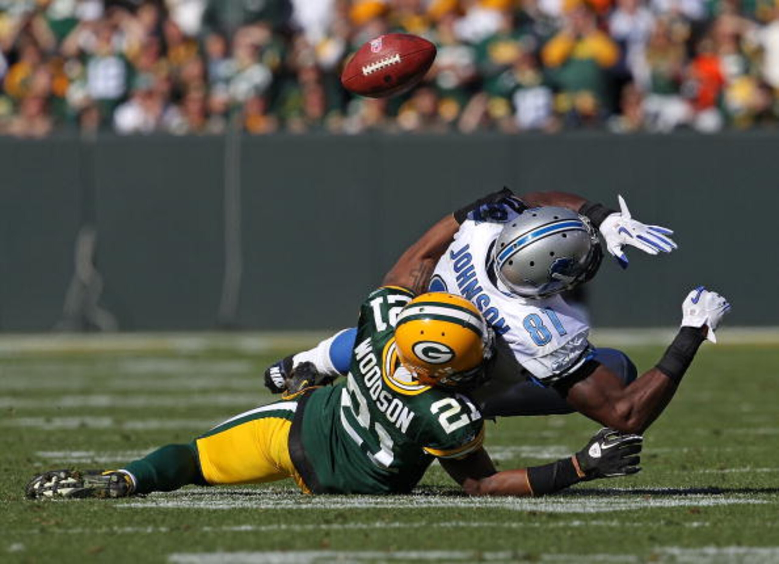 GREEN BAY, WI - OCTOBER 03: Charles Woodson #21 of the Green Bay Packers breaks up a pass intended for Calvin Johnson #81 of the Detroit Lions by taking him to the ground at Lambeau Field on October 3, 2010 in Green Bay, Wisconsin. The Packers defeated th