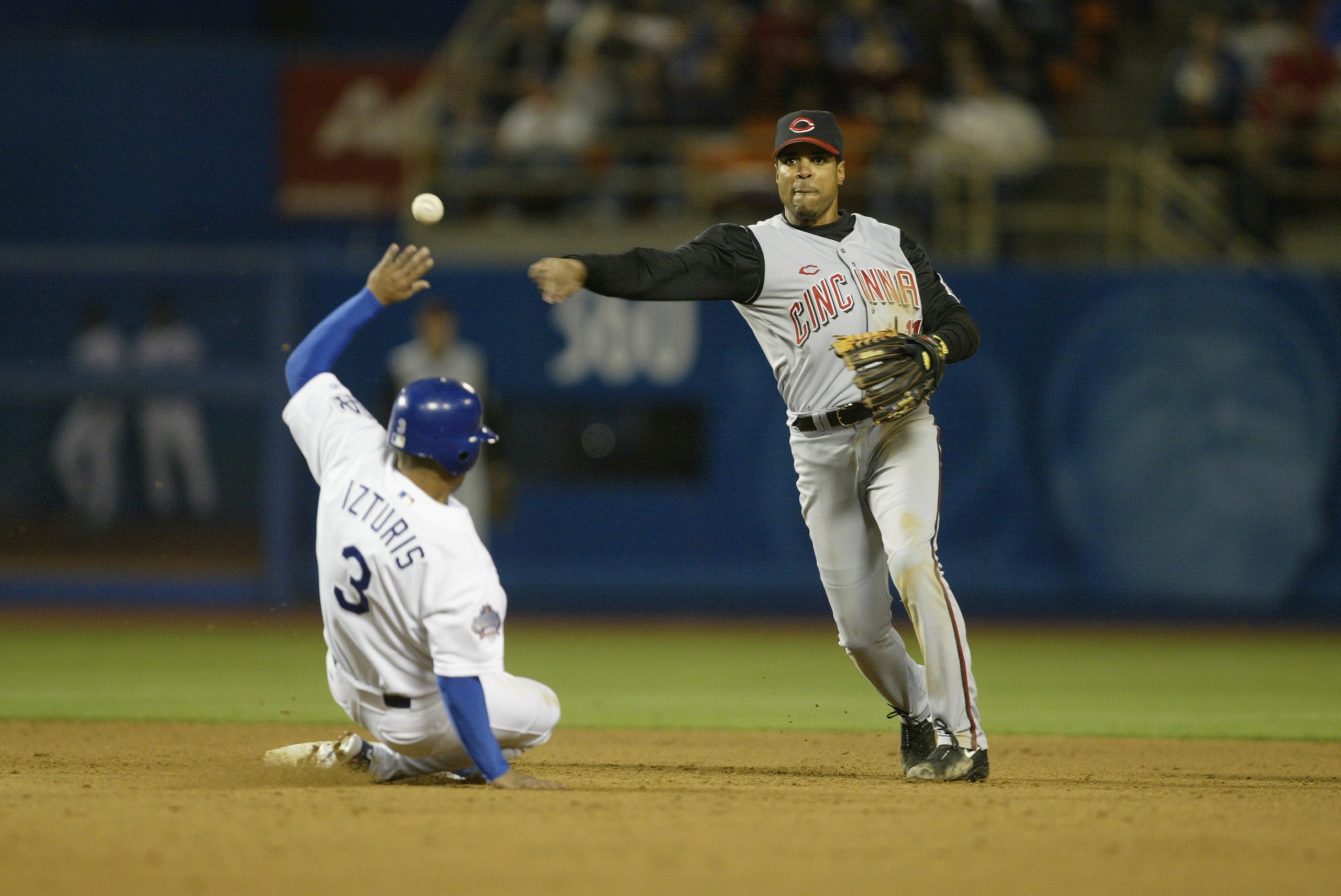 LOS ANGELES - APRIL 30:  Shortstop Barry Larkin #11 of the Cincinnati Reds turns a double play over the slide of shortstop Cesar Izturis #3 of the Los Angeles Dodgers during the MLB game on April 30, 2002 at Dodger Stadium in Los Angeles, California. The