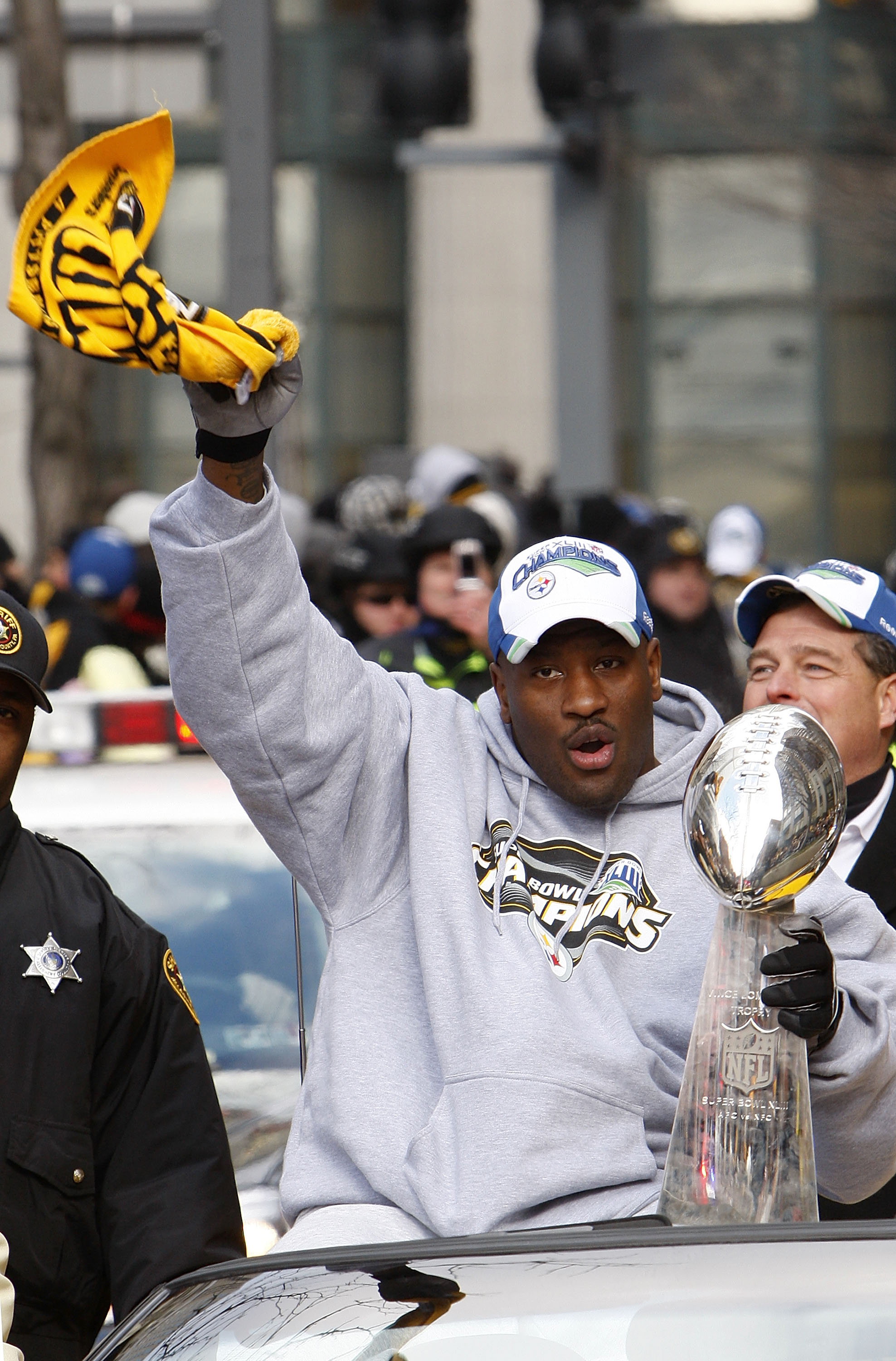 PITTSBURGH - FEBRUARY 03:  James Harrison #92 of the Pittsburgh Steelers waves a Terrible Towel while holding the Super Bowl XLIII trophy during a parade on February 3, 2009 in Pittsburgh, Pennsylvania.  (Photo by Gregory Shamus/Getty Images)