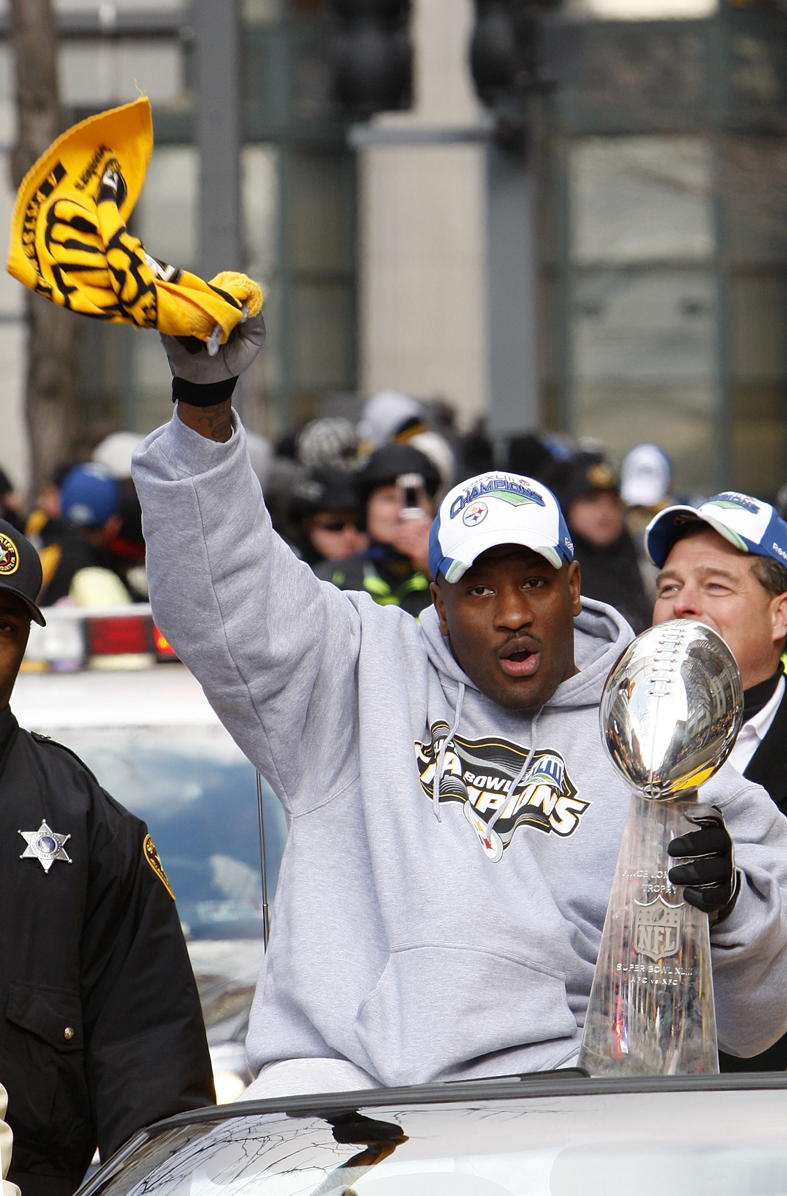 PITTSBURGH - FEBRUARY 03:  James Harrison #92 of the Pittsburgh Steelers waves a Terrible Towel while holding the Super Bowl XLIII trophy during a parade on February 3, 2009 in Pittsburgh, Pennsylvania.  (Photo by Gregory Shamus/Getty Images)