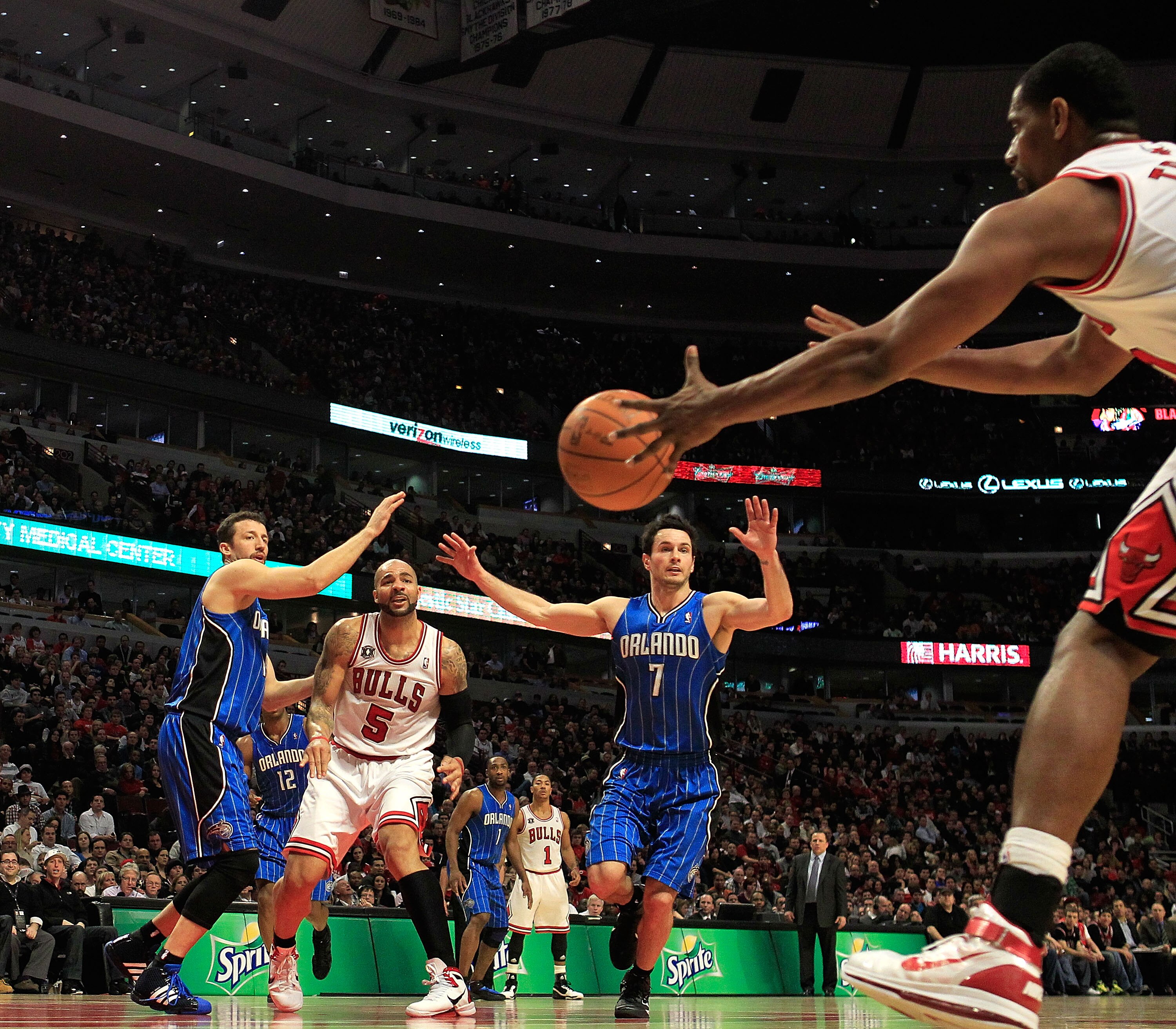 CHICAGO, IL - JANUARY 28: Carlos Boozer #5 of the Chicago Bulls passes the ball to teammate Kurt Thomas #40 under pressure from Hedo Turkoglu #15 and J.J. Redick #7 of the Orlando Magic at the United Center on January 28, 2011 in Chicago, Illinois. The Bu