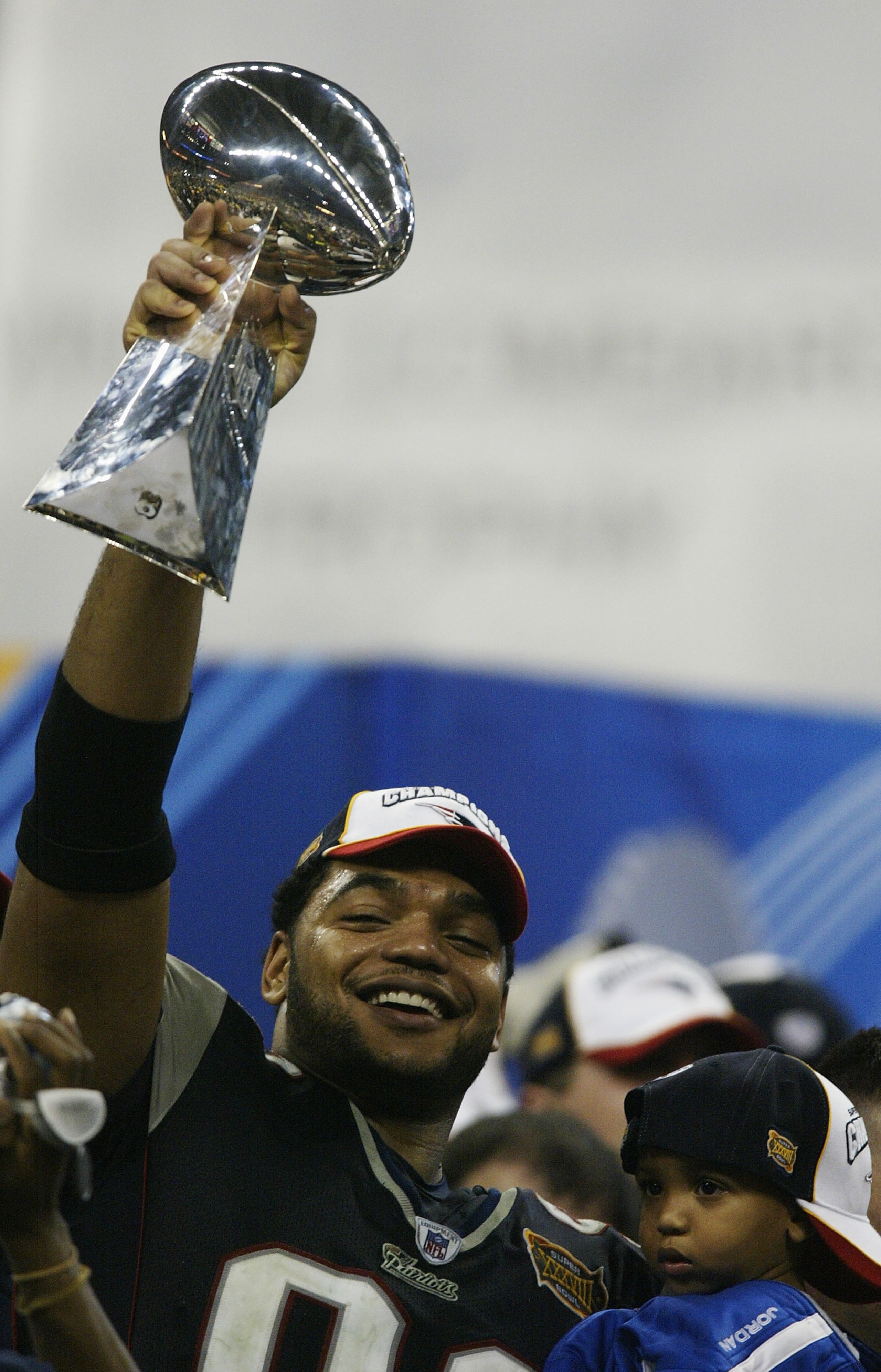 HOUSTON, TX - FEBRUARY 1:  Defensive lineman Richard Seymour #93 of the New England Patriots celebrates with the Vince Lombardi trophy after defeating the Carolina Panthers 32-29 in Super Bowl XXXVIII at Reliant Stadium on February 1, 2004 in Houston, Tex