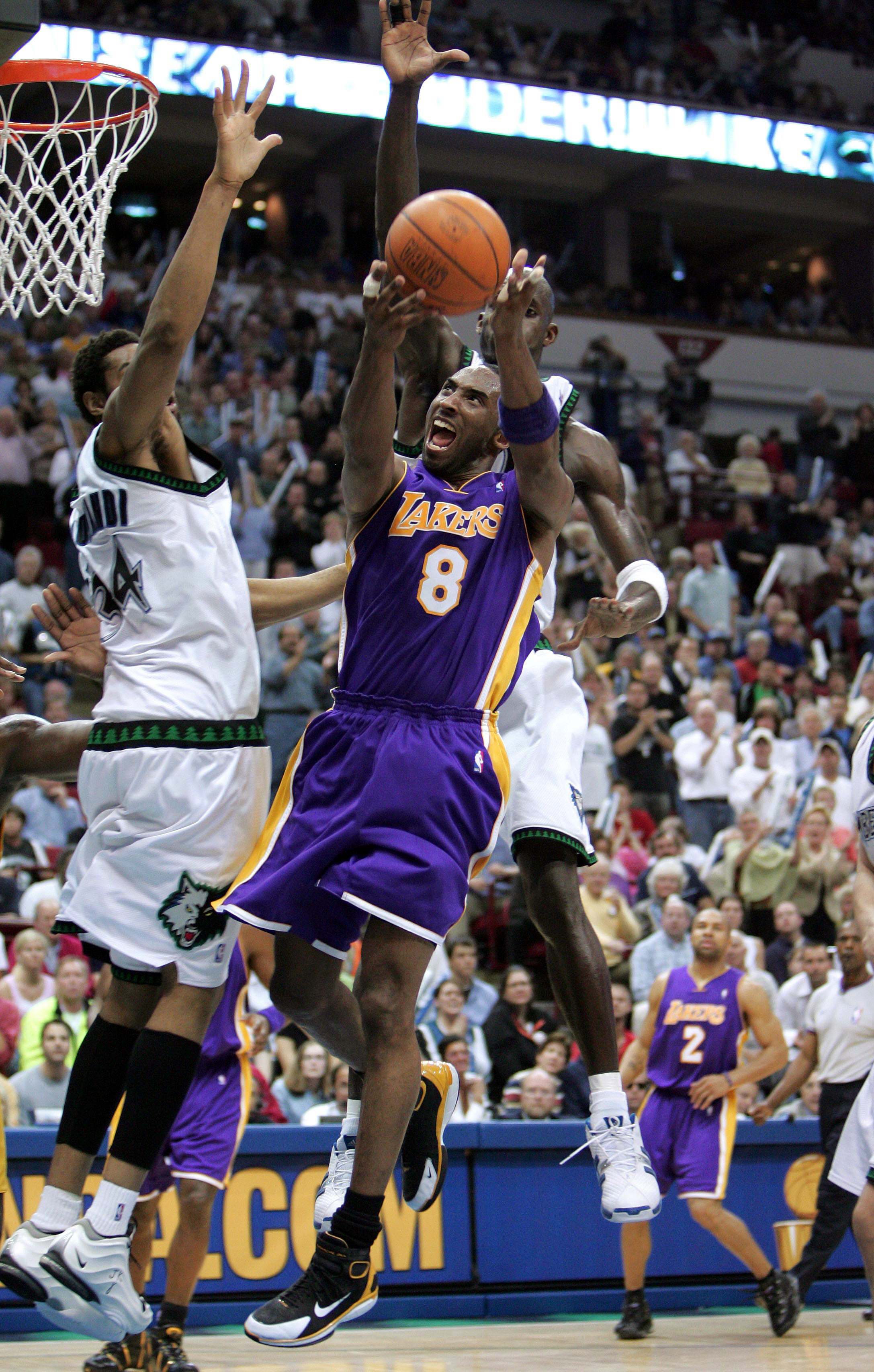 MINNEAPOLIS - MAY 29:  Kobe Bryant #8 of the Los Angeles Lakers goes to the basket under pressure from the Minnesota Timberwolves in the frist half of Game five of the Western Conference Finals during the 2004 NBA Playoffs on May 29, 2004 at Target Center
