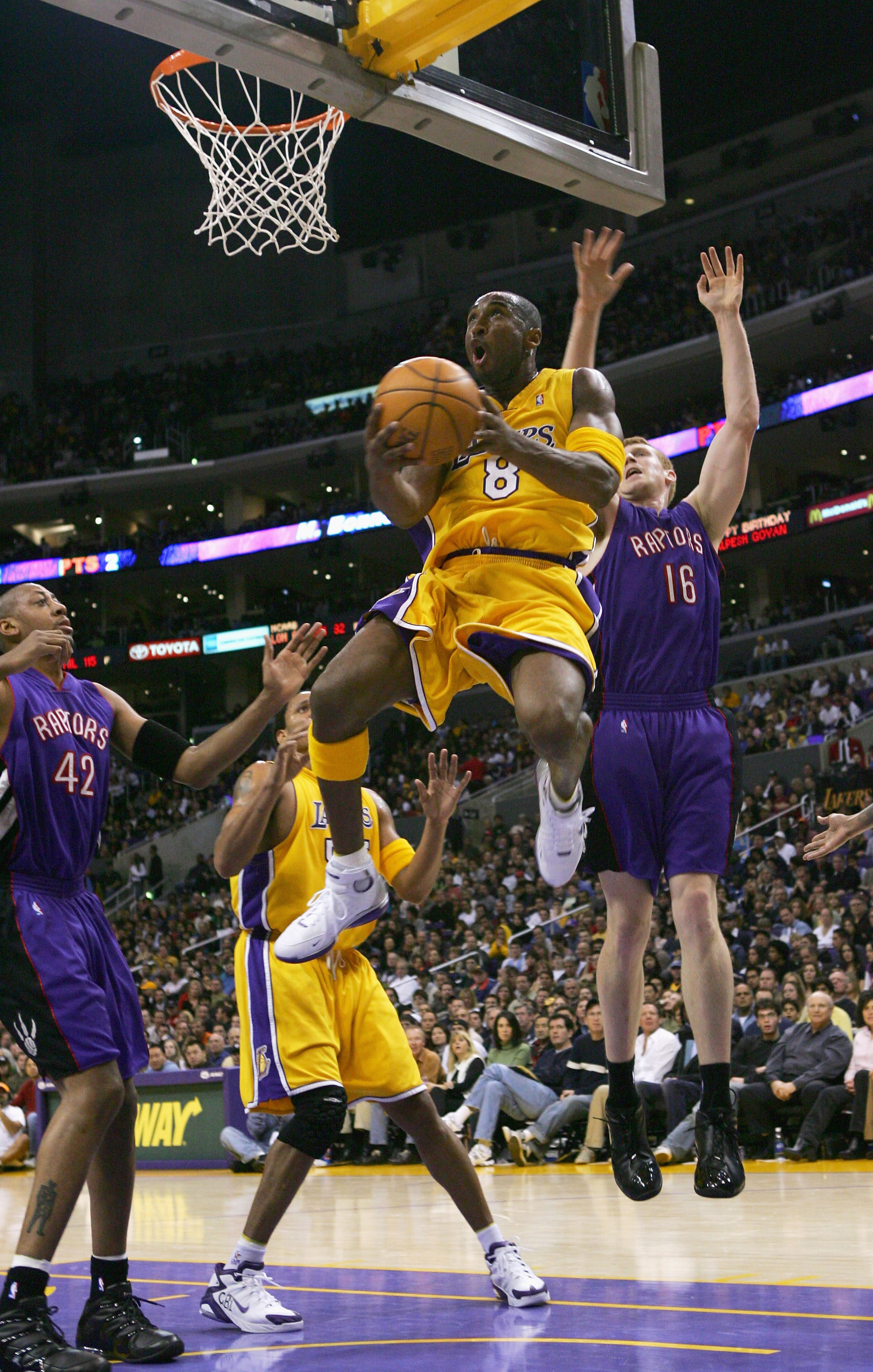 LOS ANGELES - DECEMBER 28:  Kobe Bryant #8 of the Los Angeles Lakers drives to the basket past Matt Bonner #16 of theToronto Raptors during the game on December 28, 2004 at Staples Center in Los Angeles, California.  The Lakers defeated the Raptors 117-99