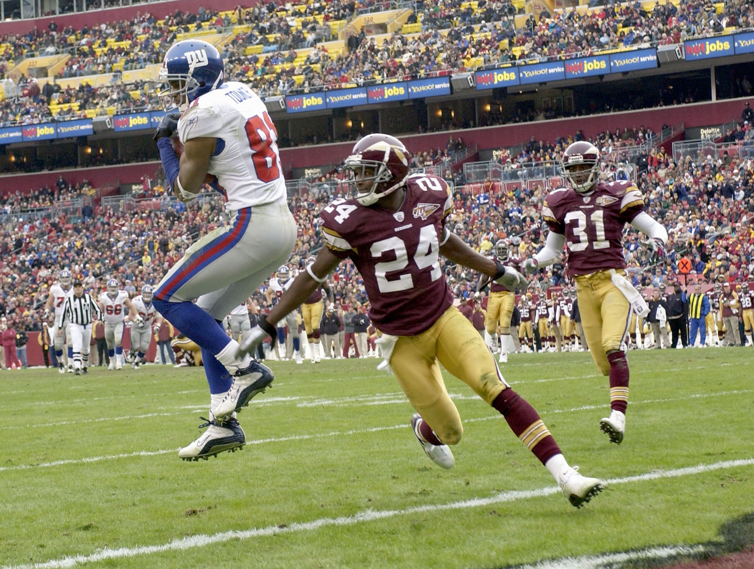 LANDOVER, MD - DECEMBER 8:  Amani Toomer #81 of the New York Giants catches the ball in the end zone in front of the Champ Bailey #24 of the Washington Redskins to give the Giants a 16-0 lead  on December 8, 2002 at FedEx Field in Landover, Maryland. (Pho