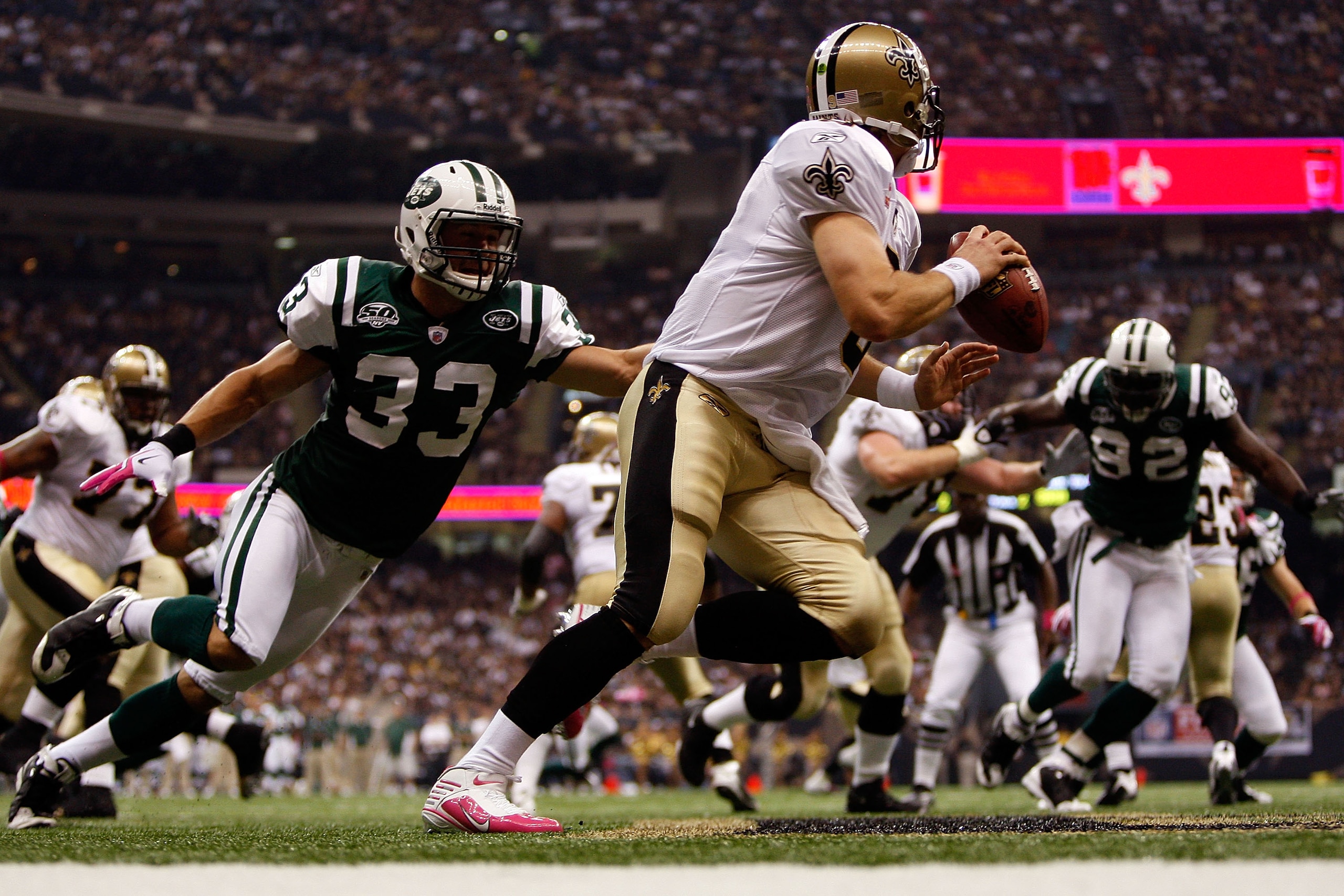 NEW ORLEANS - OCTOBER 04:  Drew Brees #9 of the New Orleans Saints avoids a tackle by Eric Smith #33 of the New York Jets at the Louisana Superdome on October 4, 2009 in New Orleans, Louisiana.  (Photo by Chris Graythen/Getty Images)