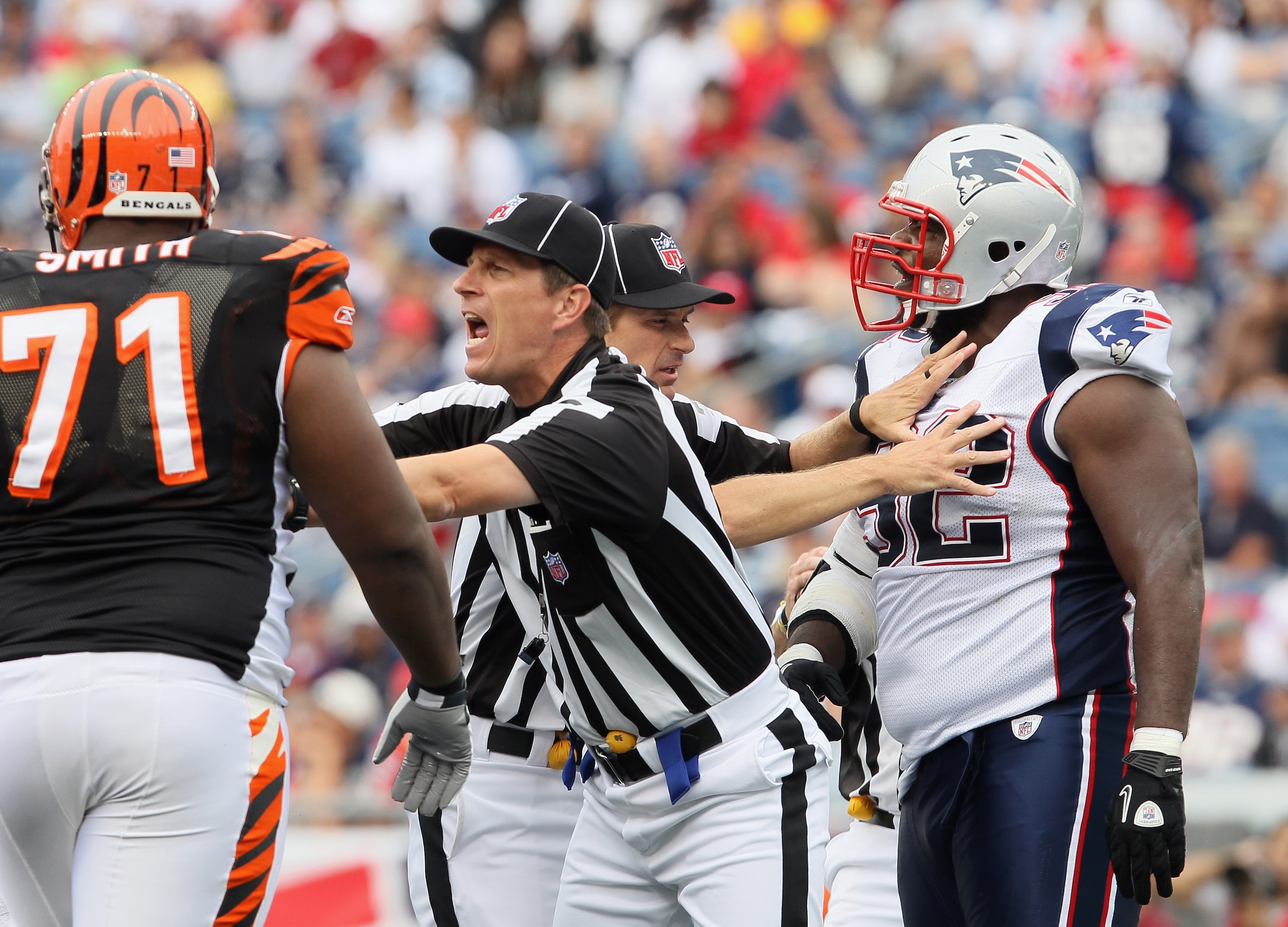 FOXBORO, MA - SEPTEMBER 12:  The officiasl break up a scuffle between Andre Smith #71 of the Cincinnati Bengals and Gerard Warren #92 of the New England Patriots during the NFL season opener on September 12, 2010 at Gillette Stadium in Foxboro, Massachuse