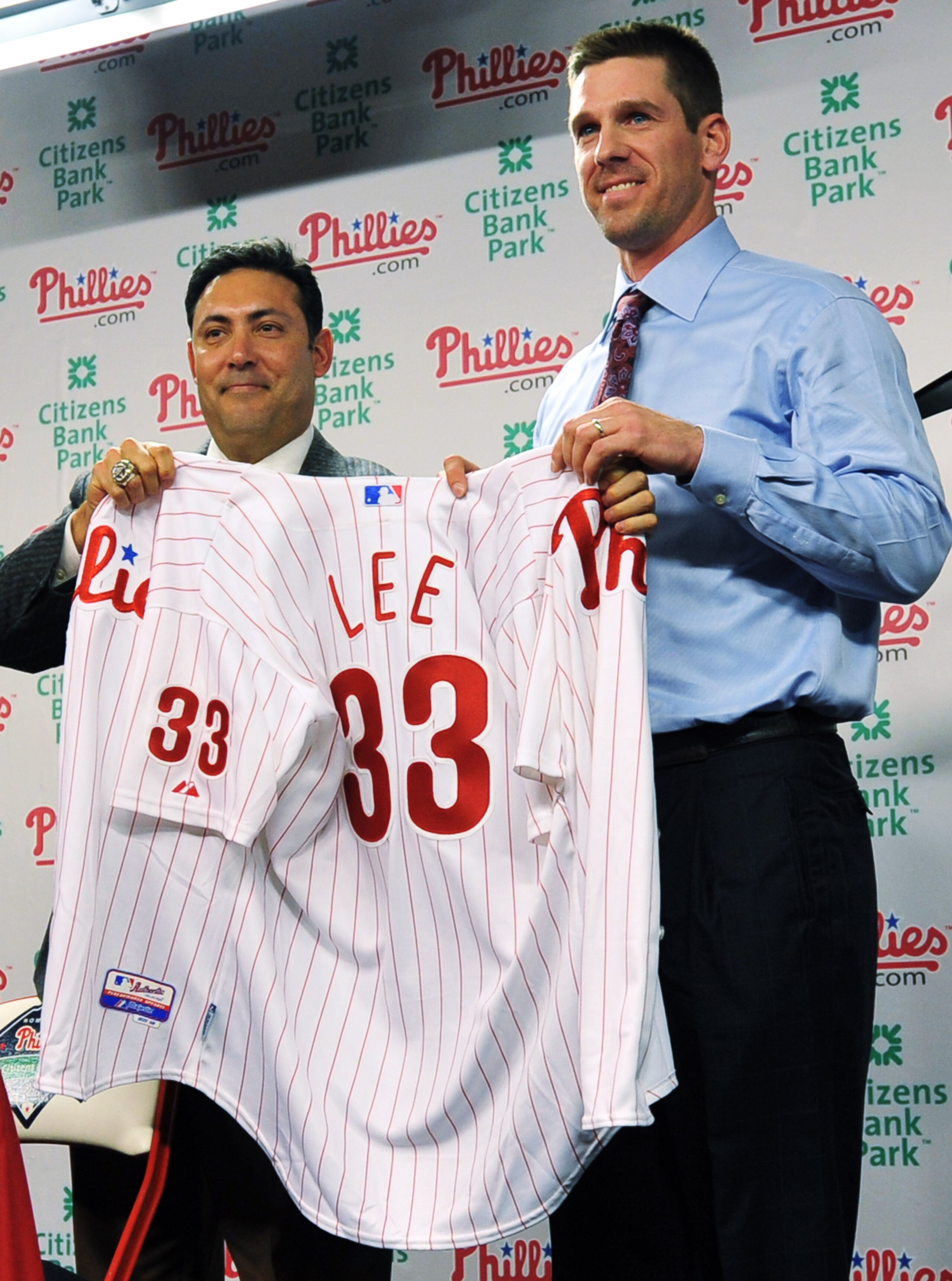 PHILADELPHIA - DECEMBER 15:  Pitcher Cliff Lee (R) #33 of the Philadelphia Phillies is introduced to the media and presented his jersey by the Philadelphia Phillies general manager Ruben Amaro Jr. during a press conference at Citizens Bank Park on Decembe