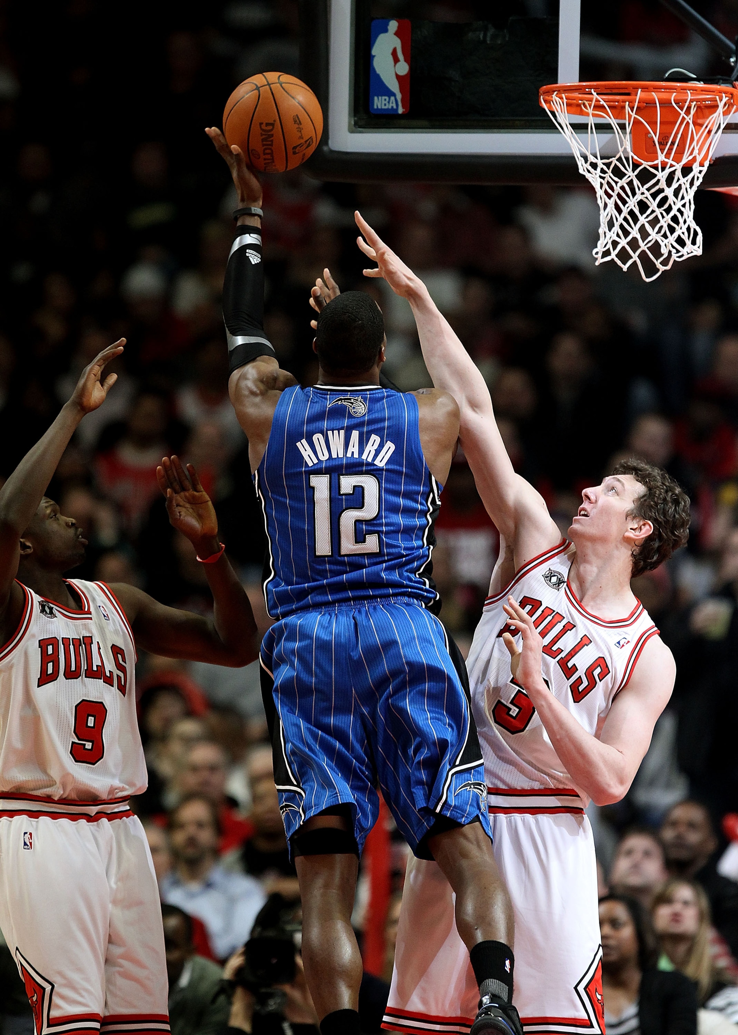 CHICAGO, IL - JANUARY 28: Dwight Howard #12 of the Orlando Magic puts up a shot between Loul Deng #9 and Omer Asik #3 of the the Chicago Bulls on his way to a game-high 40 points at the United Center on January 28, 2011 in Chicago, Illinois. The Bulls def