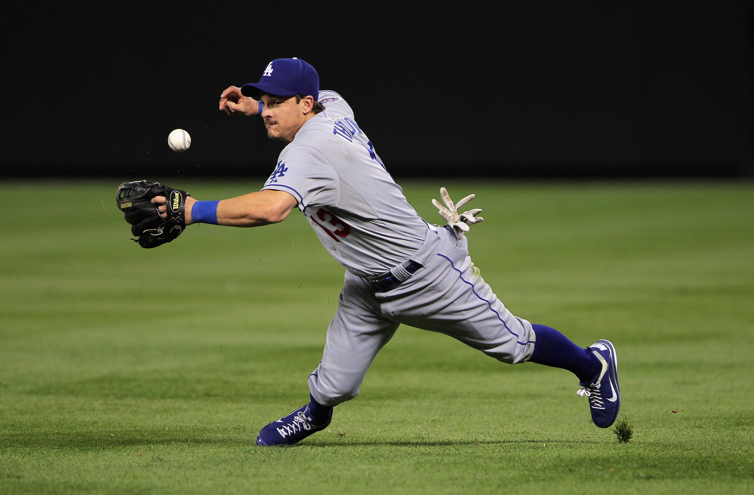 DENVER - SEPTEMBER 27:  Second baseman Ryan Theriot #13 of the Los Angeles Dodgers makes the stop on a ground ball by Todd Helton of the Colorado Rockies but looses the handle on the ball and is unable to throw out Helton at Coors Field on September 25, 2