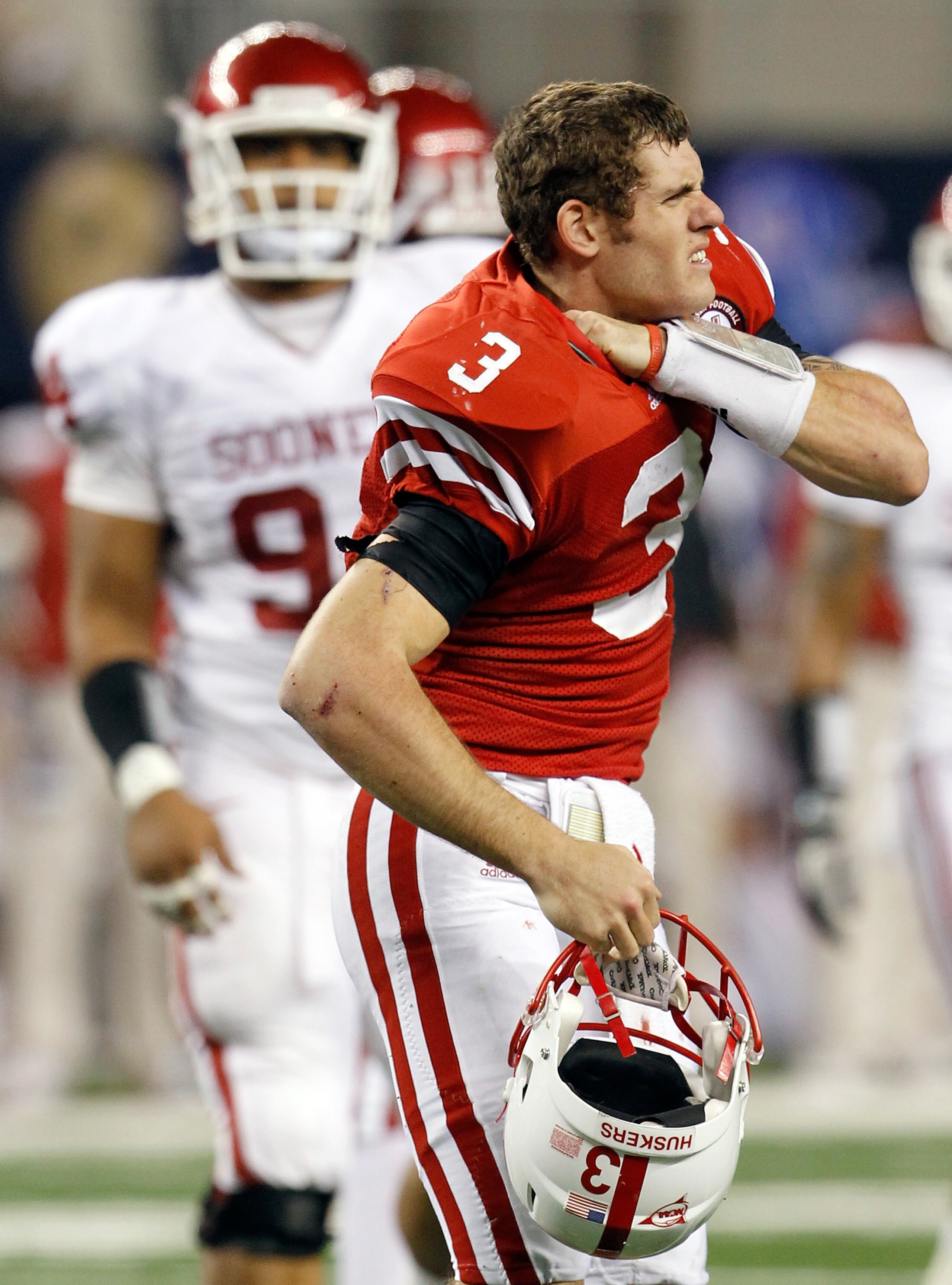 ARLINGTON, TX - DECEMBER 04:  Quarterback Taylor Martinez #3 of the Nebraska Cornhuskers adjusts his shoulder pads after being hit by the Oklahoma Sooners at Cowboys Stadium on December 4, 2010 in Arlington, Texas.  The Sooners beat the Cornhuckers 23-20.