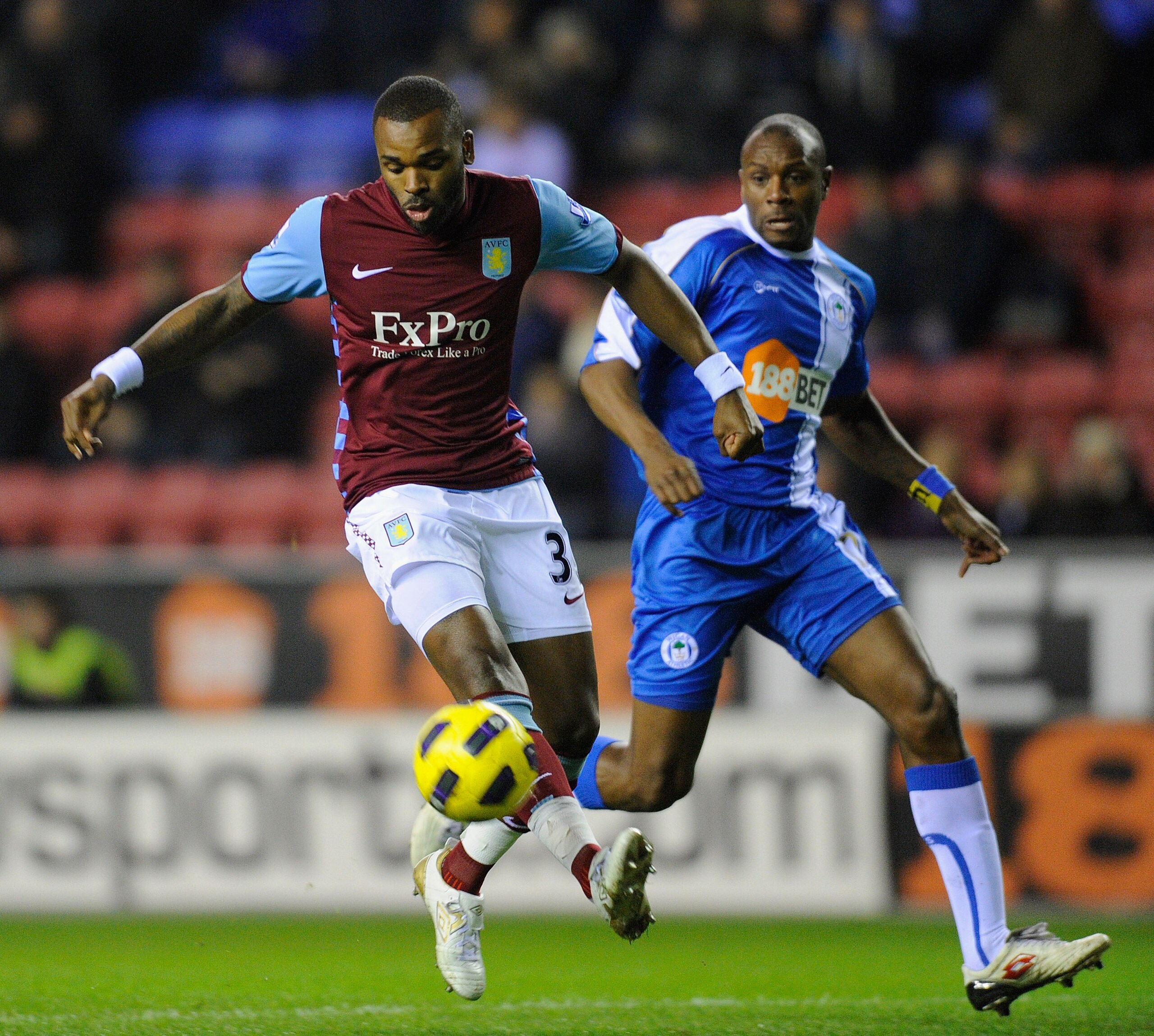 WIGAN, ENGLAND - JANUARY 25: Darren Bent of Aston Villa controls the ball ahead of Emmerson Boyce of Wigan during the Barclays Premier League match between Wigan Athletic and Aston Villa at the DW Stadium on January 25, 2011 in Wigan, England.  (Photo by