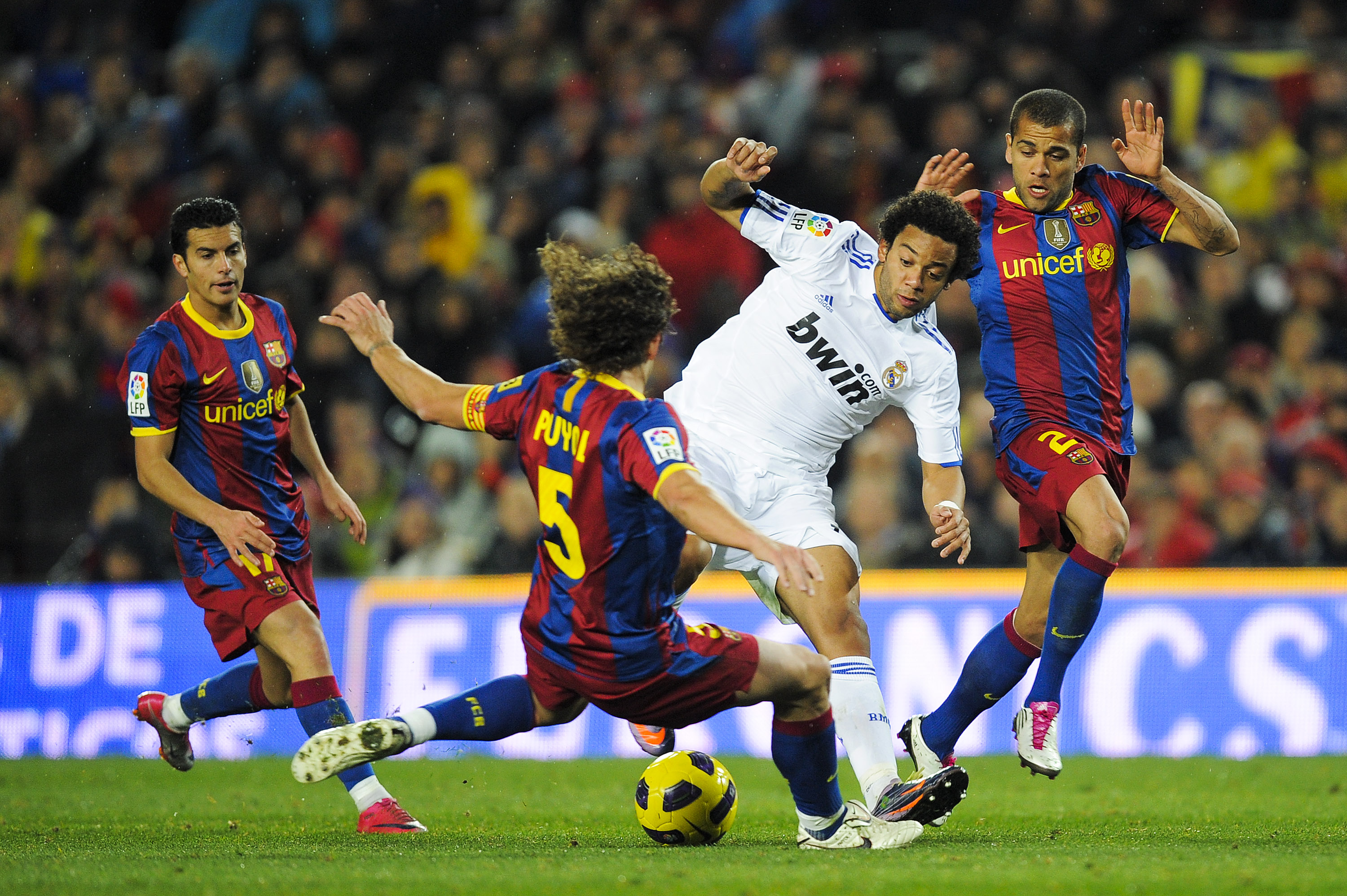 BARCELONA, SPAIN - NOVEMBER 29:  Marcelo Vieira of Real Madrid (2ndR) vies for the ball against Carles Puyol (2ndL) and Dani Alves (R) of Barcelona during the La Liga match between Barcelona and Real Madrid at the Camp Nou Stadium on November 29, 2010 in