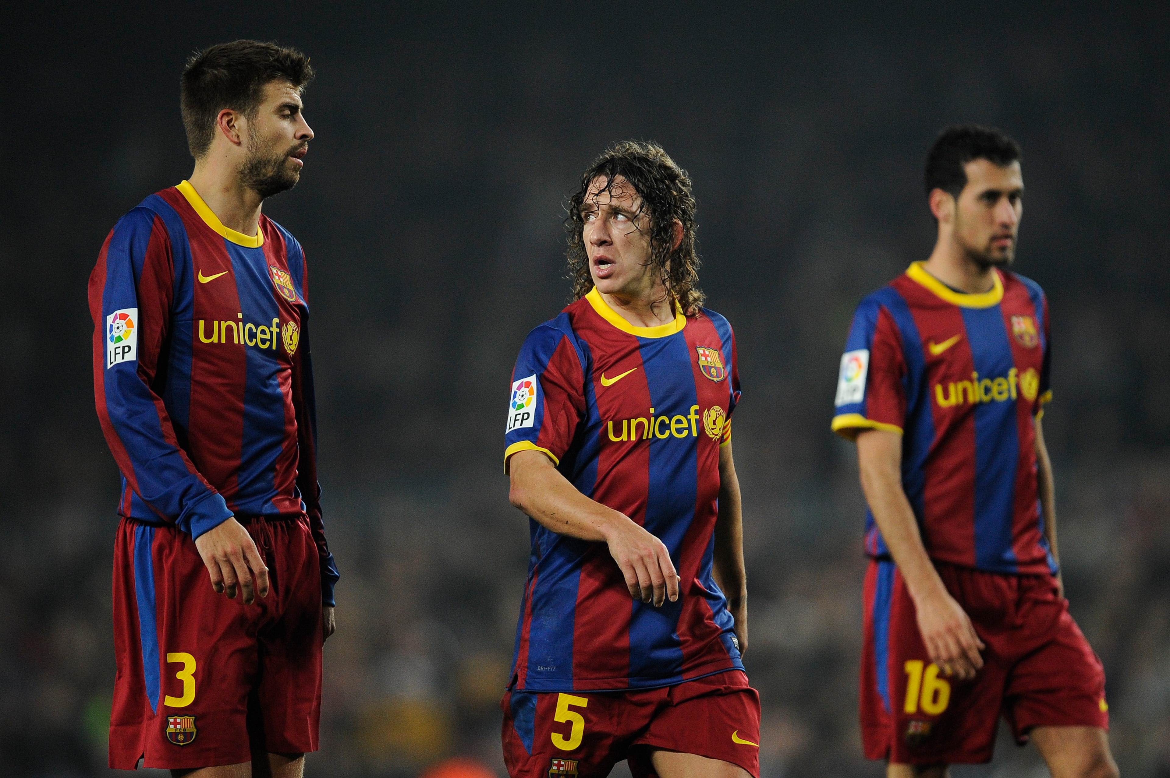 BARCELONA, SPAIN - JANUARY 16: Gerard Pique (L), Carles Puyol (C) and Sergio Busquets of FC Barcelona look on during the La Liga match between FC Barcelona and Malaga at Nou Camp on January 16, 2011 in Barcelona, Spain. Barcelona won 4-1. (Photo by Davi BARCELONA, SPAIN - JANUARY 16: Gerard Pique (L), Carles Puyol (C) and Sergio Busquets of FC Barcelona look on during the La Liga match between FC Barcelona and Malaga at Nou Camp on January 16, 2011 in Barcelona, Spain. Barcelona won 4-1. (Photo by Davi