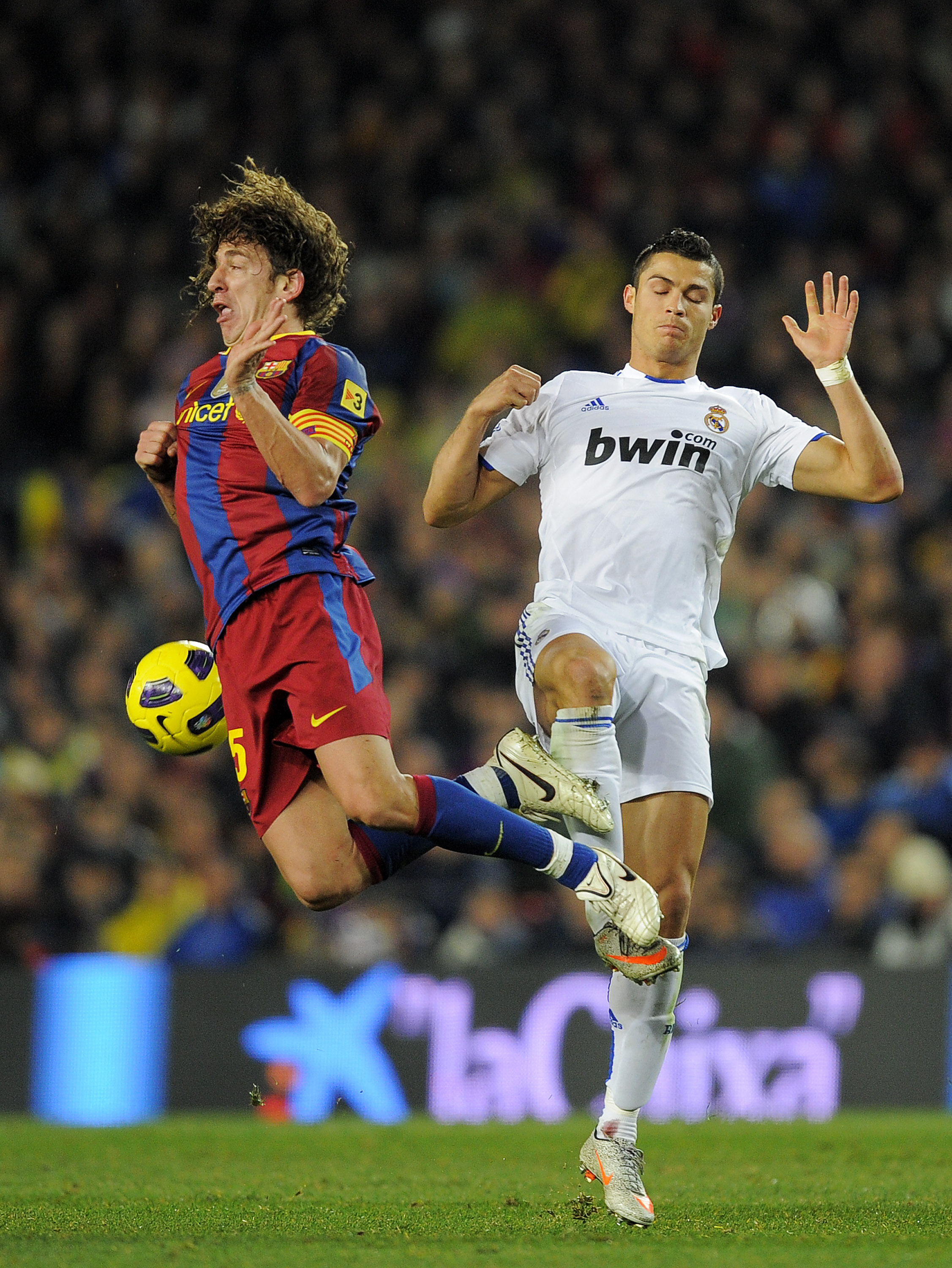 BARCELONA, SPAIN - NOVEMBER 29:  Carles Puyol of Barcelona (L) vies for the ball with Cristiano Ronaldo of Real Madrid during the La Liga match between Barcelona and Real Madrid at the Camp Nou Stadium on November 29, 2010 in Barcelona, Spain.  Barcelona