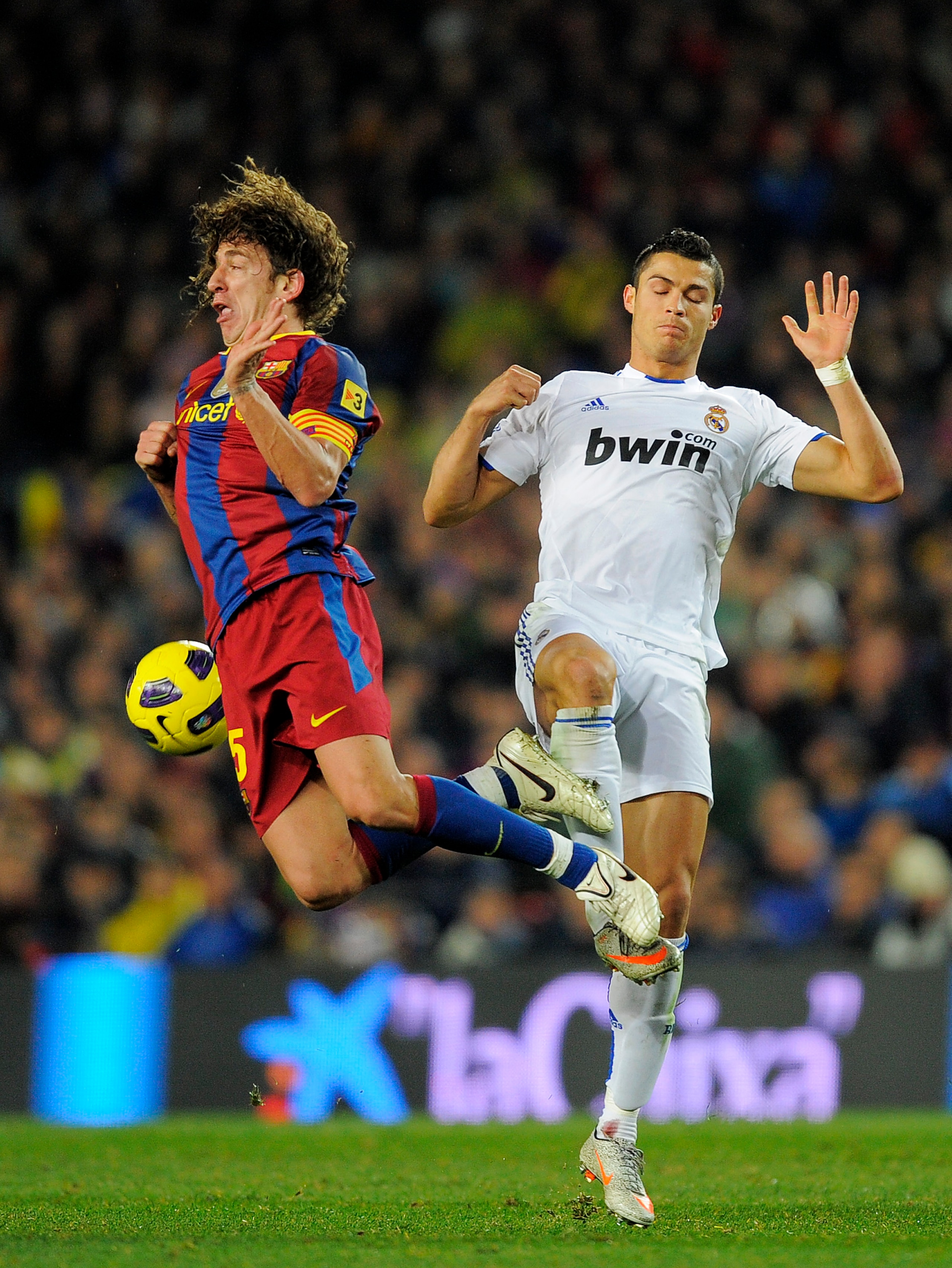 BARCELONA, SPAIN - NOVEMBER 29:  Carles Puyol of Barcelona (L) vies for the ball with Cristiano Ronaldo of Real Madrid during the La Liga match between Barcelona and Real Madrid at the Camp Nou Stadium on November 29, 2010 in Barcelona, Spain.  Barcelona