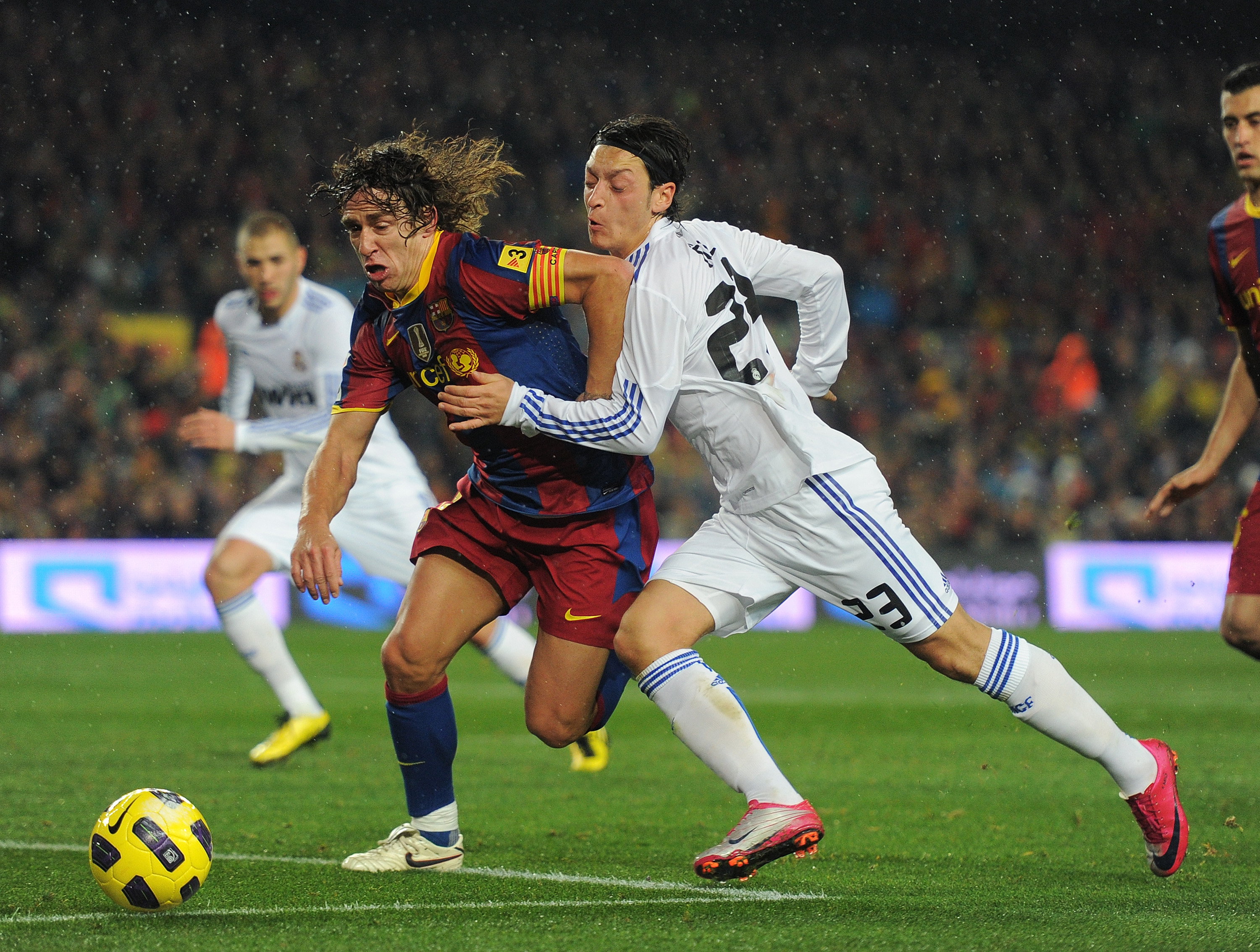 BARCELONA, SPAIN - NOVEMBER 29:  Mesut Ozil (R) of Real Madrid duels for the ball with Carles Puyol of Barcelona during the la liga match between Barcelona and Real Madrid at the Camp Nou stadium on November 29, 2010 in Barcelona, Spain.  (Photo by Jasper