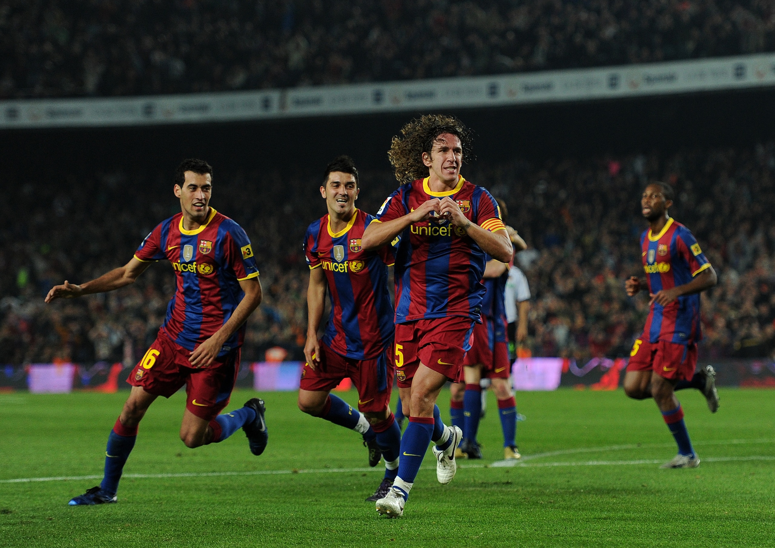 BARCELONA, SPAIN - OCTOBER 16:  Carles Puyol (R) of Barcelona celebrates scoring his sides second goal with his teammates Sergio Busquets (L) and David Villa (C) during the La Liga match between Barcelona and Valencia at the Camp Nou stadium on October 16