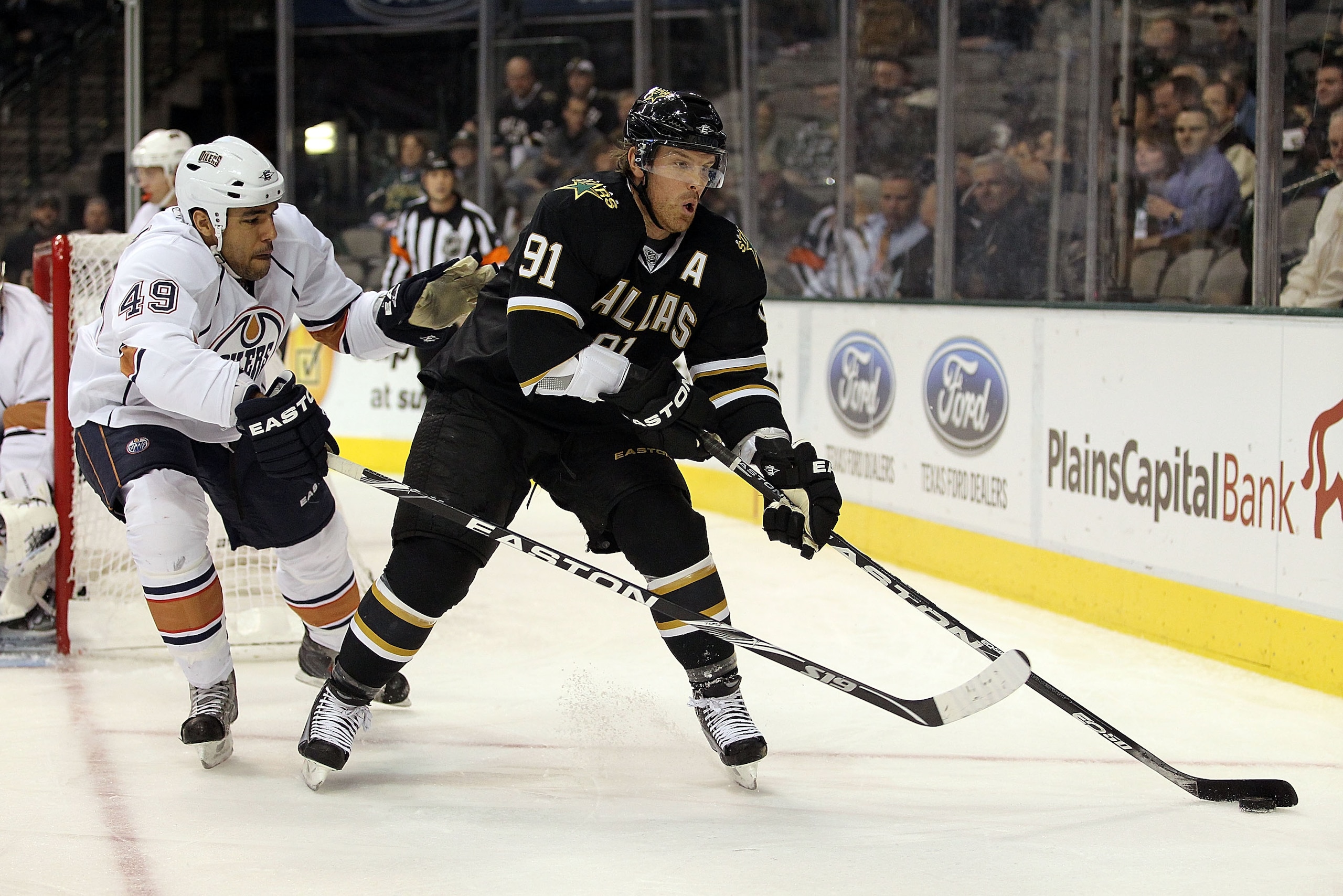 DALLAS, TX - JANUARY 26:  Center Brad Richards #91 of the Dallas Stars skates the puck past Theo Peckham #49 of the Edmonton Oilers at American Airlines Center on January 26, 2011 in Dallas, Texas.  (Photo by Ronald Martinez/Getty Images)