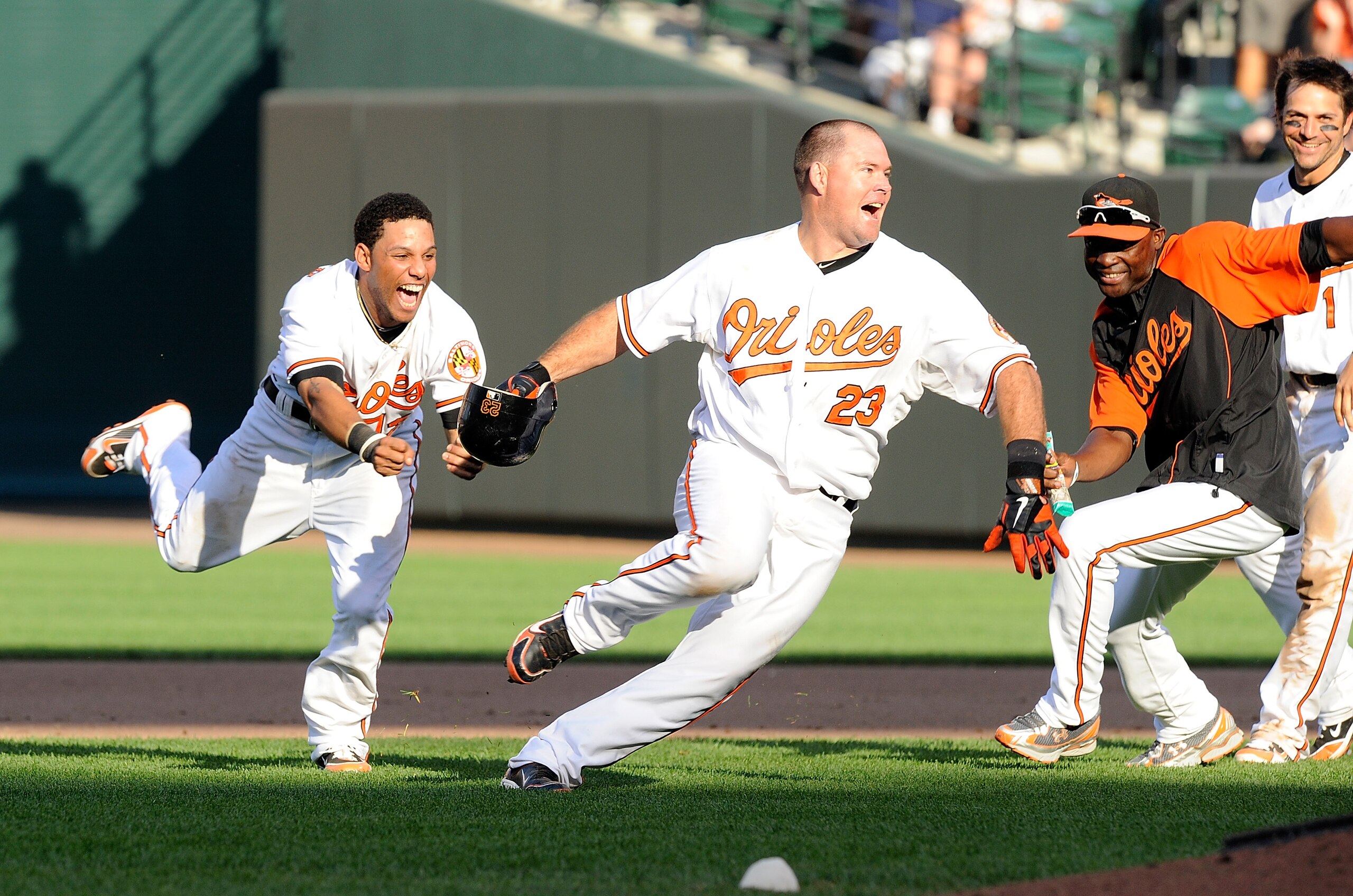 BALTIMORE - SEPTEMBER 19:  Ty Wigginton #23 of the Baltimore Orioles is chased by Robert Andino #12 after driving in the game winning run in the eleventh inning against the New York Yankees at Camden Yards on September 19, 2010 in Baltimore, Maryland. The