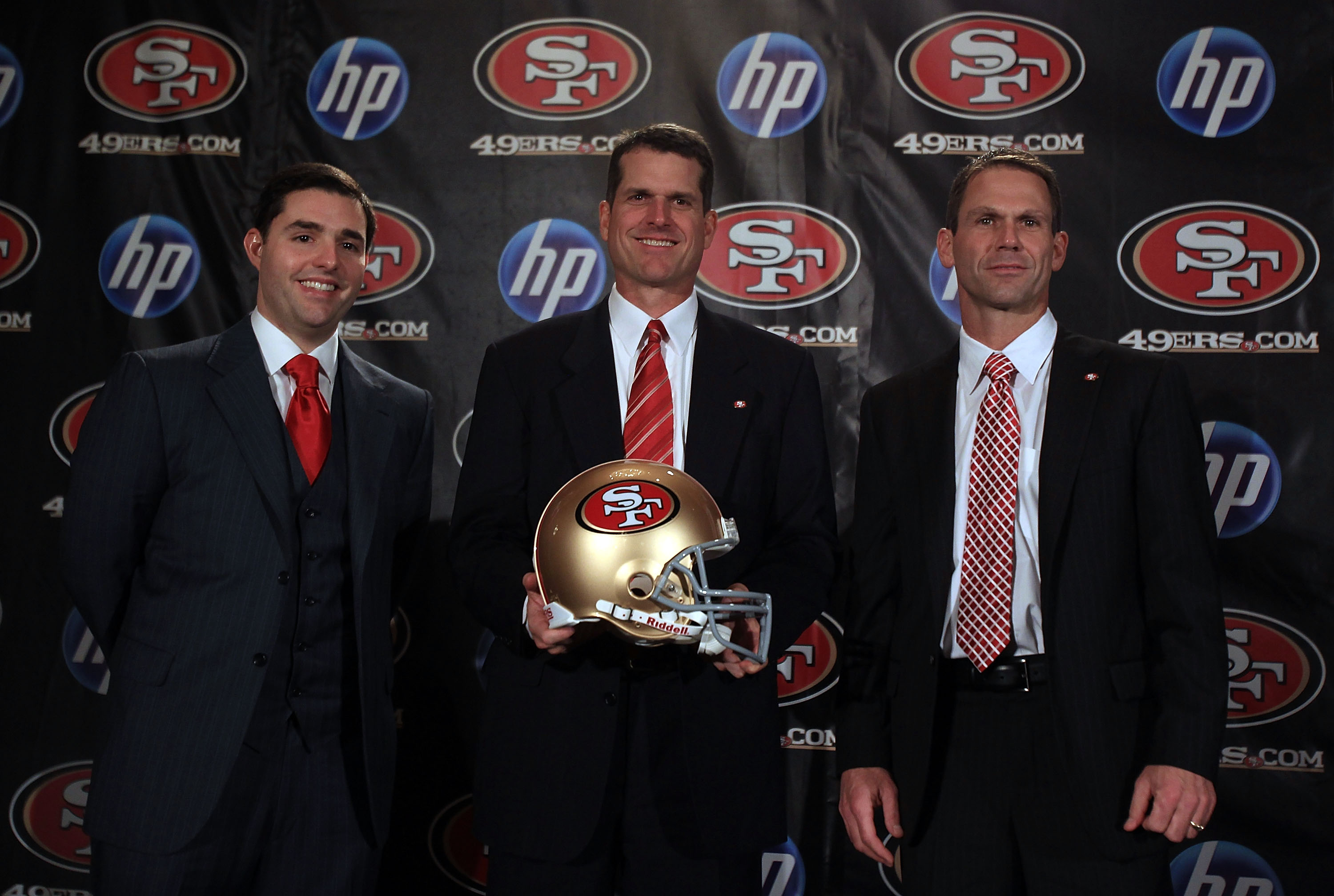 SAN FRANCISCO, CA - JANUARY 07: Jim Harbaugh poses for a picture with President and CEO of the San Francisco 49ers, Jed York, (left) and general manager Trent Baalk following a press conference where Harbaugh was introduced as the new San Francisco 49ers