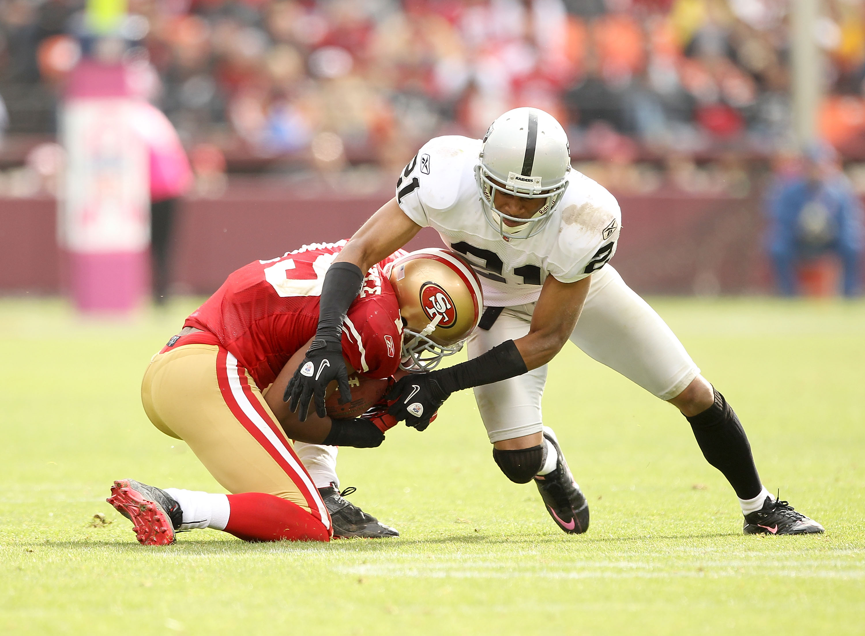 SAN FRANCISCO - OCTOBER 17: Nnamdi Asomugha #21 of the Oakland Raiders tackles Michael Crabtree #15 of the San Francisco 49ers at Candlestick Park on October 17, 2010 in San Francisco, California. (Photo by Ezra Shaw/Getty Images)