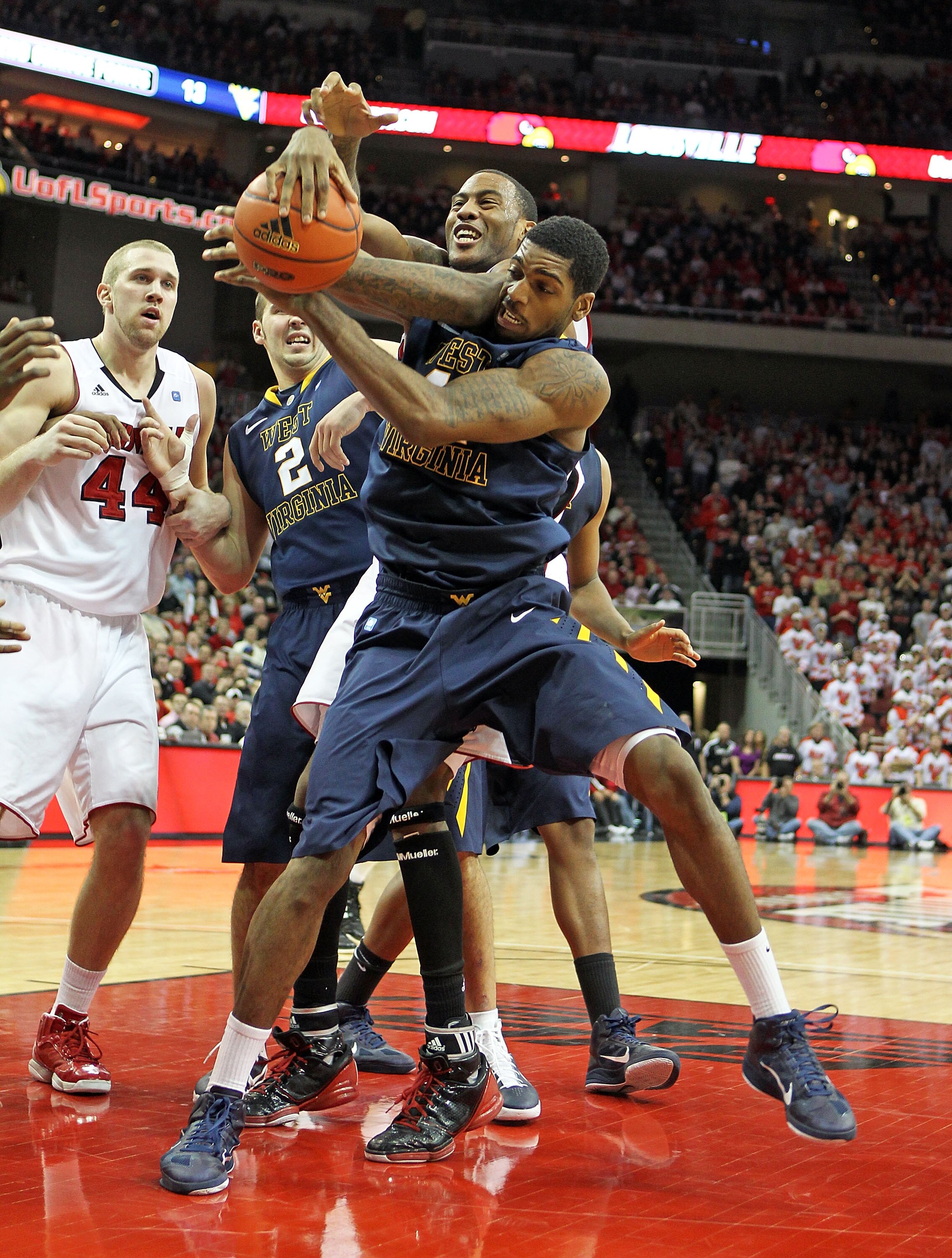 LOUISVILLE, KY - JANUARY 26:  John Flowers #41 of the West Virginia Mountaineers grabs the ball while defended by Terrence Jennings #23 of the Louisville Cardinals during the Big East Conference game at the KFC Yum! Center on January 26, 2011 in Louisvill