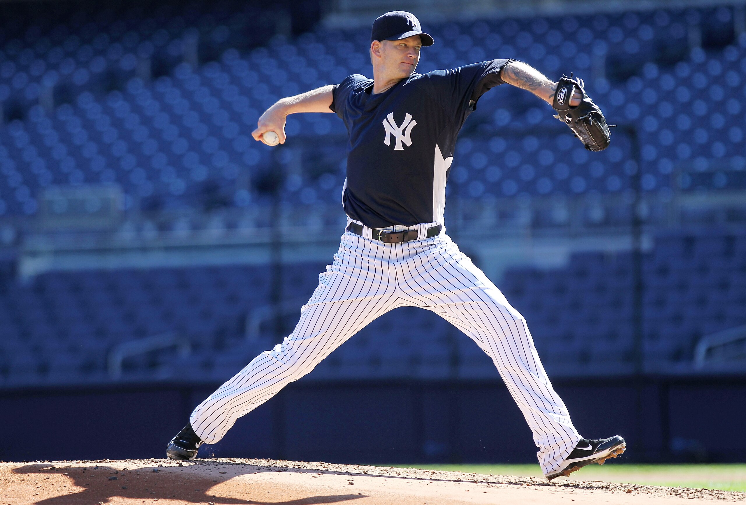 NEW YORK - OCTOBER 13:  A.J. Burnett #34 of the New York Yankees pitches during a workout session at Yankee Stadium on October 13, 2010 in the Bronx borough of New York City.  (Photo by Nick Laham/Getty Images)
