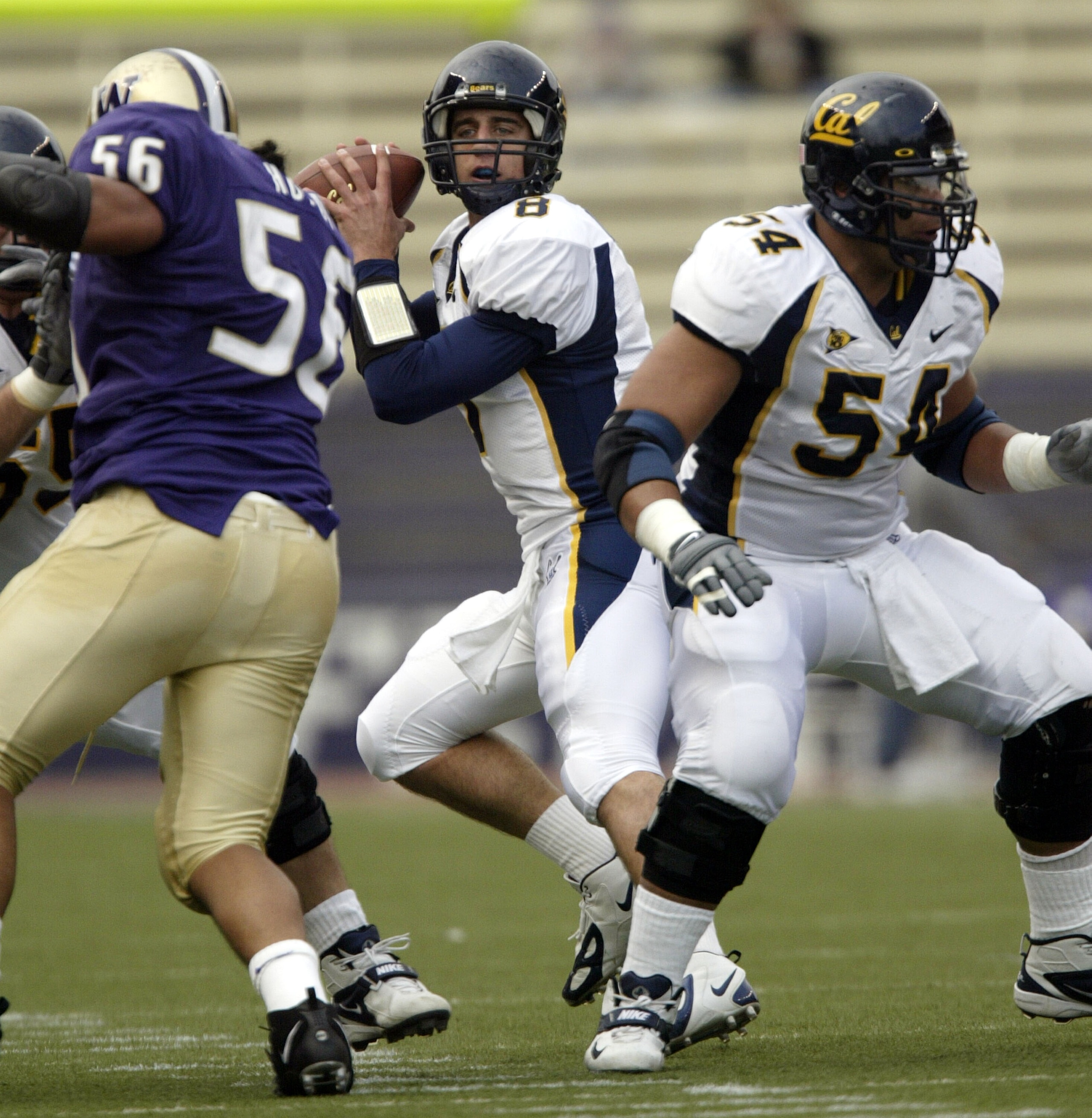 SEATTLE - NOVEMBER 13:  Quarterback Aaron Rodgers #8 of the California Golden Bears drops back to pass against Manase Hopoi #56 of the Washington Huskies while Marvin Philip #54 watches on November 13. 2004 at Husky Stadium in Seattle, Washington.  (Photo