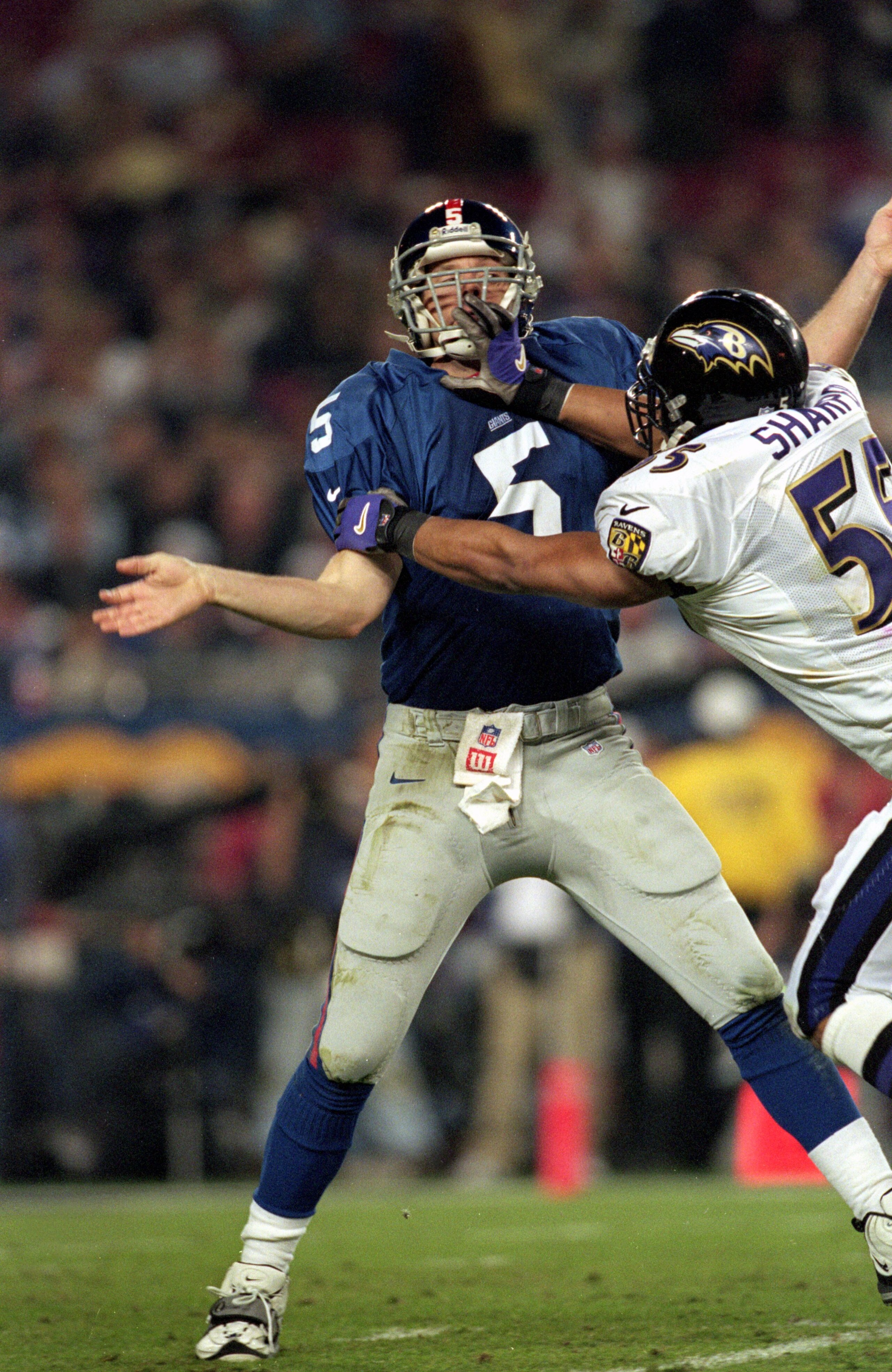 28 Jan 2001:  Quarterback Kerry Collins #5 of the New York Giants is grabbed by the face mask by Jamie Sharper #55 of the Baltimore Ravens during the Super Bowl XXXV Game at the Raymond James Stadium in Tampa, Florida. The Ravens defeated the Giants 34-7.