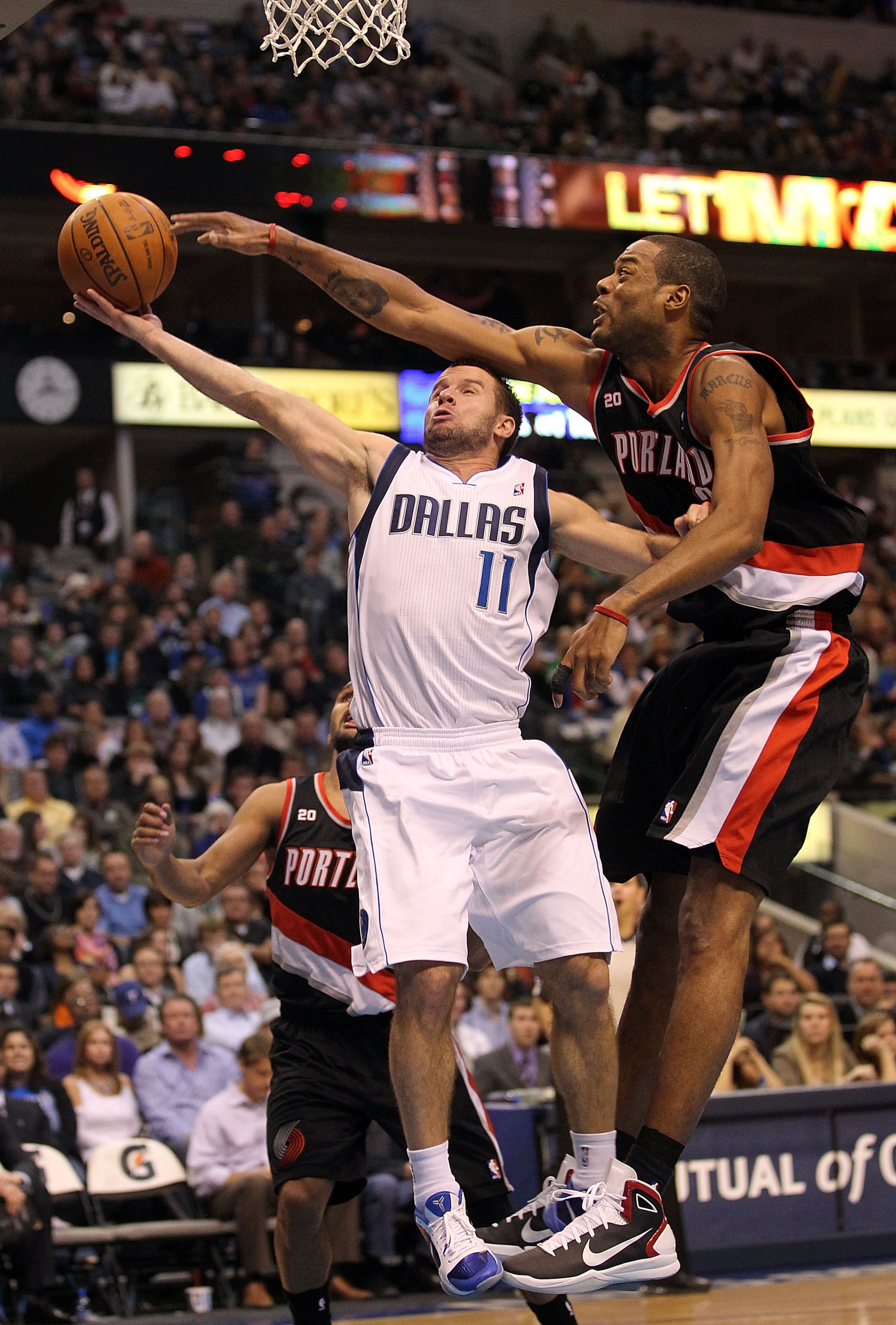 DALLAS, TX - JANUARY 04:  Guard Jose Juan Barea #11 of the Dallas Mavericks takes a shot against Marcus Camby #23 of the Portland Trail Blazers at American Airlines Center on January 4, 2011 in Dallas, Texas.  NOTE TO USER: User expressly acknowledges and