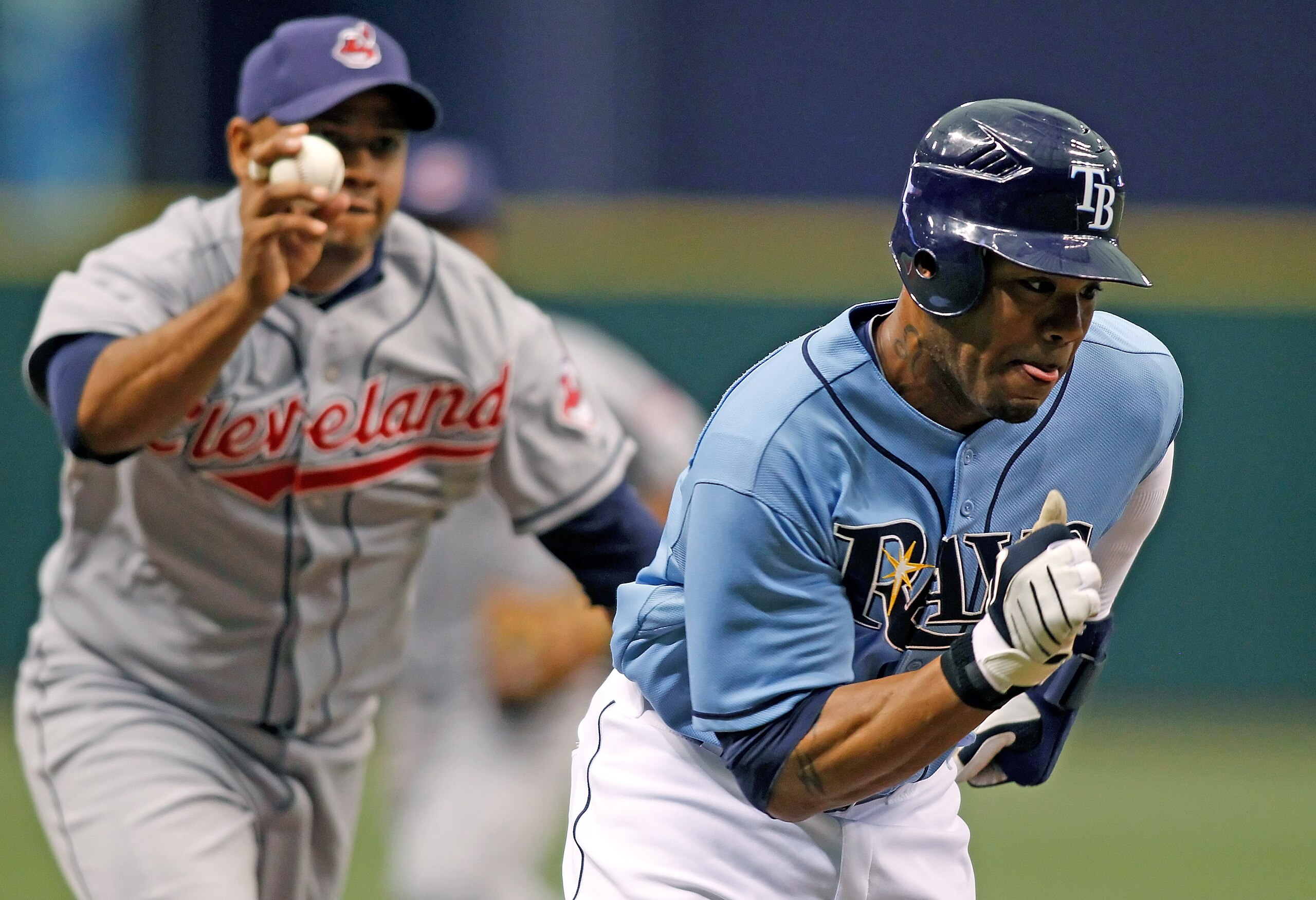 ST. PETERSBURG - JULY 11:  Outfielder Carl Crawford #13 of the Tampa Bay Rays gets caught in a run down as infielder Andy Marte #25 of the Cleveland Indians tries to chase him down at Tropicana Field on July 11, 2010 in St. Petersburg, Florida.  (Photo by