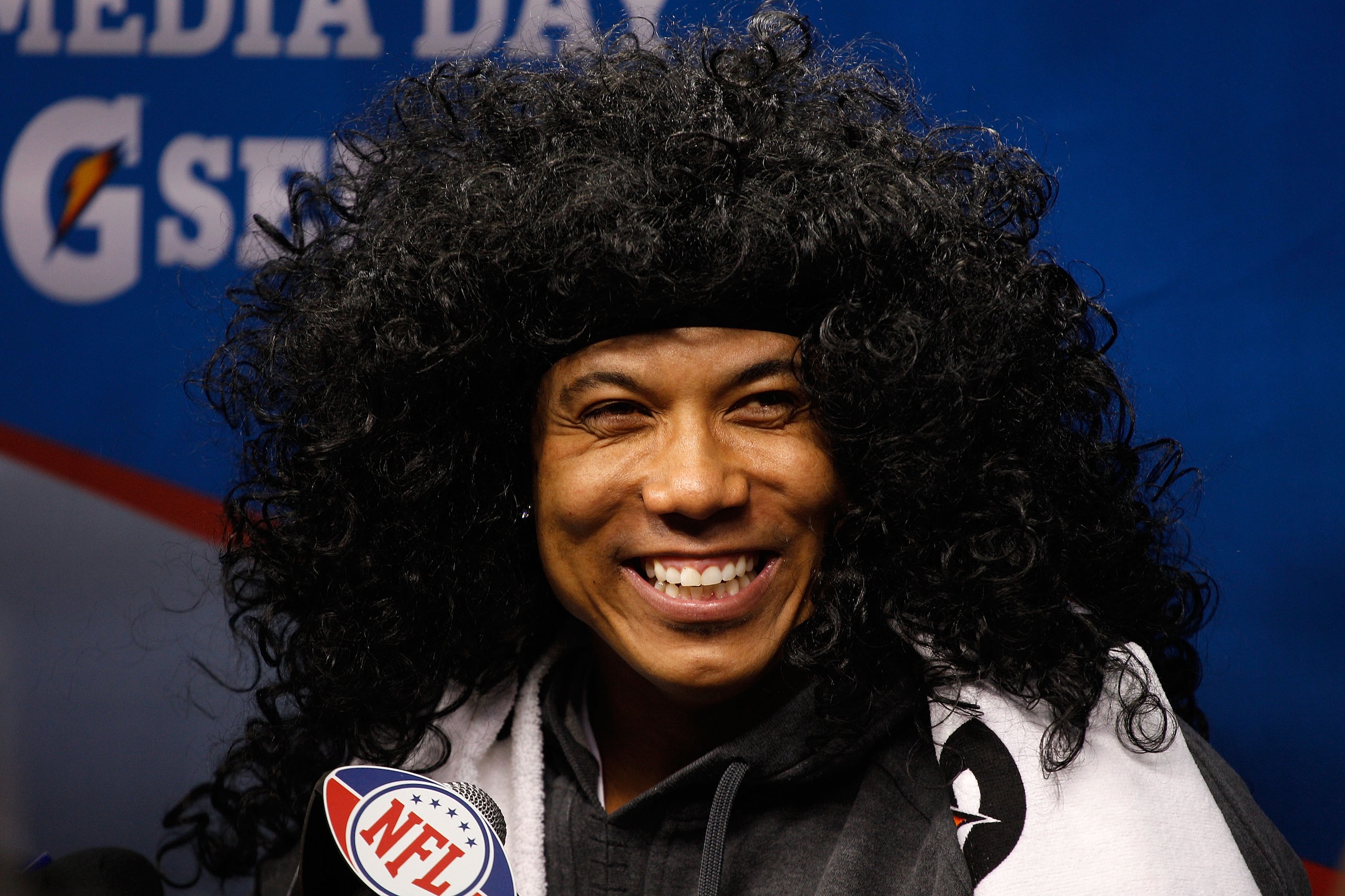 ARLINGTON, TX - FEBRUARY 01:  Hines Ward #86 of the Pittsburgh Steelers smiles as he wears a Troy Polamalu wig as he is on the podium during Super Bowl XLV Media Day ahead of Super Bowl XLV at Cowboys Stadium on February 1, 2011 in Arlington, Texas. The P