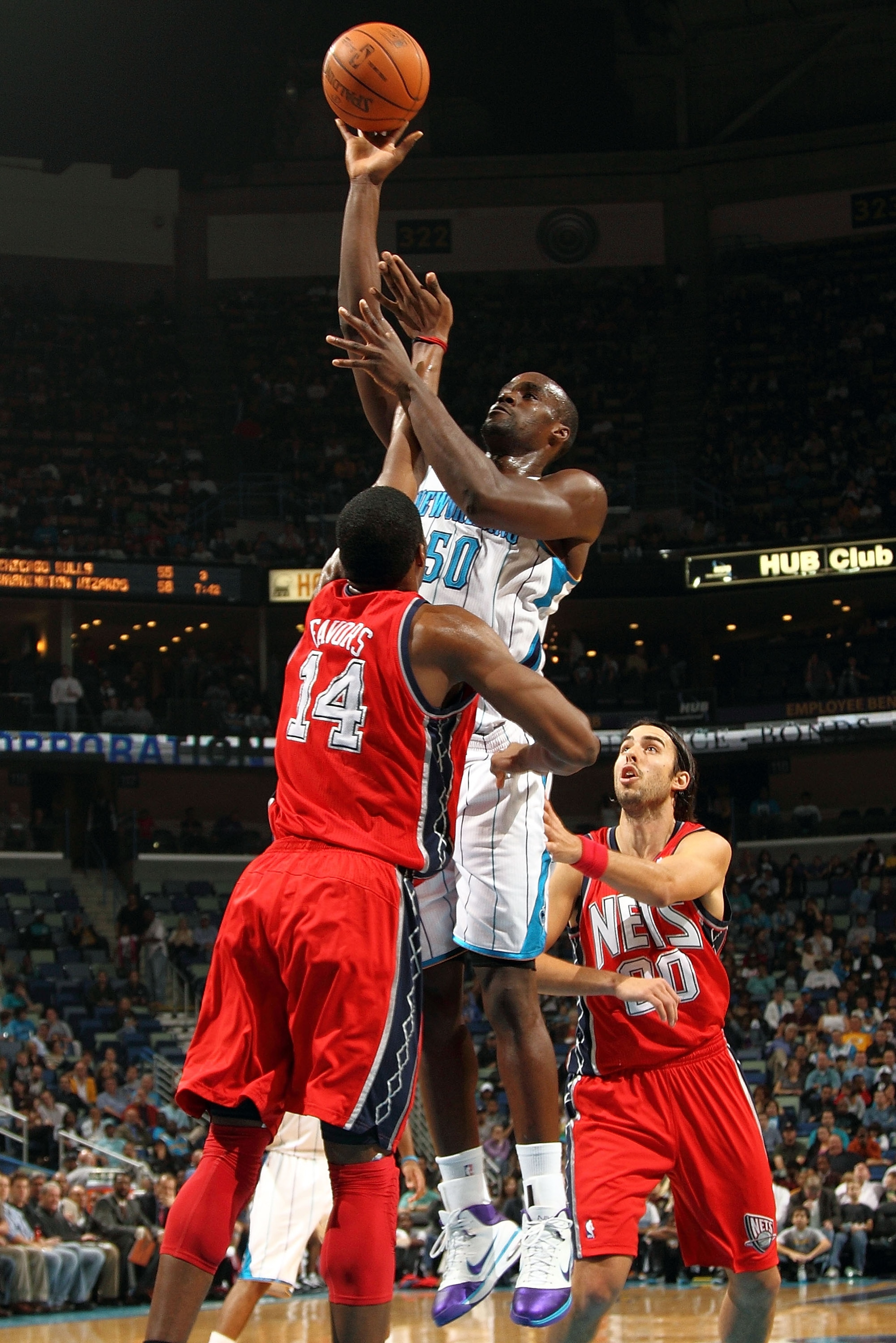 NEW ORLEANS, LA - DECEMBER 22:  Emeka Okafor #50 of the New Orleans Hornets shoots the ball over Derrick Favors #14 of the New Jersey Nets at the New Orleans Arena on December 22, 2010 in New Orleans, Louisiana.  The Hornets defeated the Nets 105-91.   NO