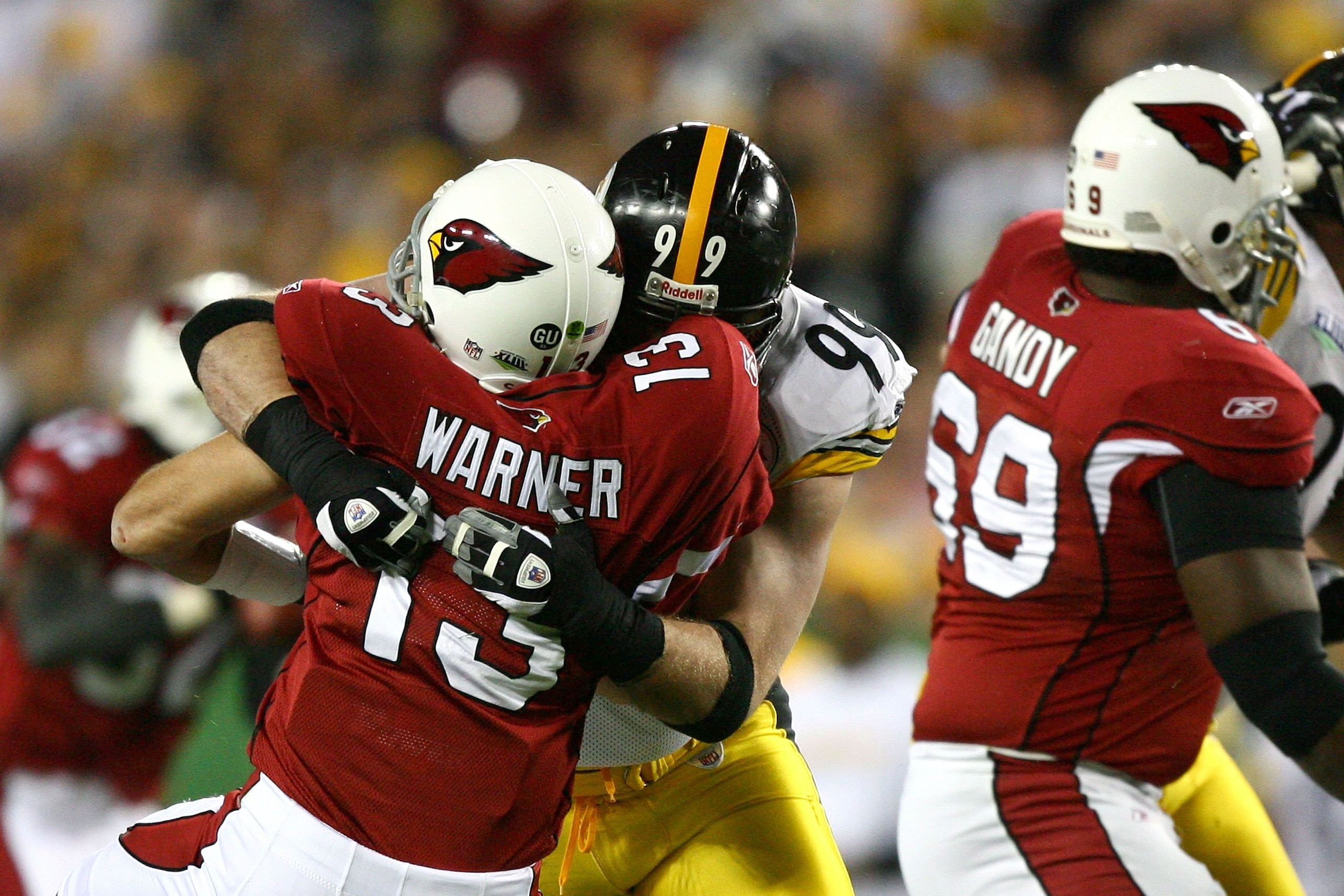 TAMPA, FL - FEBRUARY 01:  Quarterbeck Kurt Warner #13 of the Arizona Cardinals is hit by Brett Keisel #99 of the Pittsburgh Steelers during Super Bowl XLIII on February 1, 2009 at Raymond James Stadium in Tampa, Florida. The Steelers won 27-23. (Photo by 
