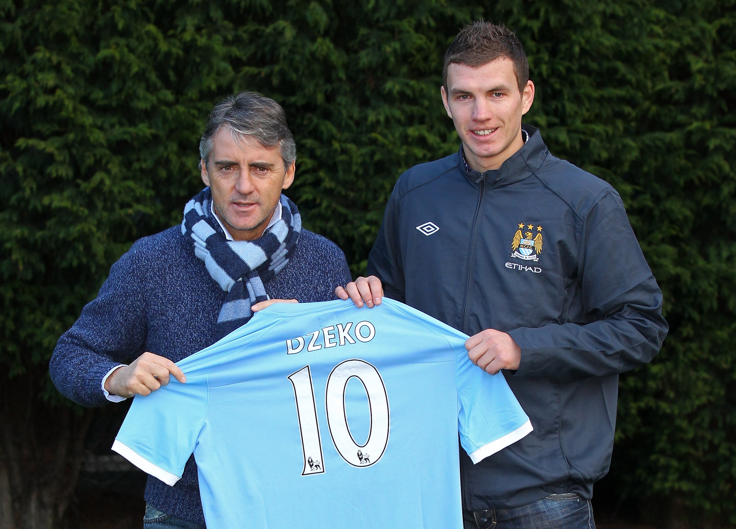 MANCHESTER, ENGLAND - JANUARY 11:  Edin Dzeko the new signing for Manchester City poses with Roberto Mancini the manager of Manchester City during a photocall at the Carrington Training Complex on January 11, 2011 in Manchester, England.  (Photo by Alex L