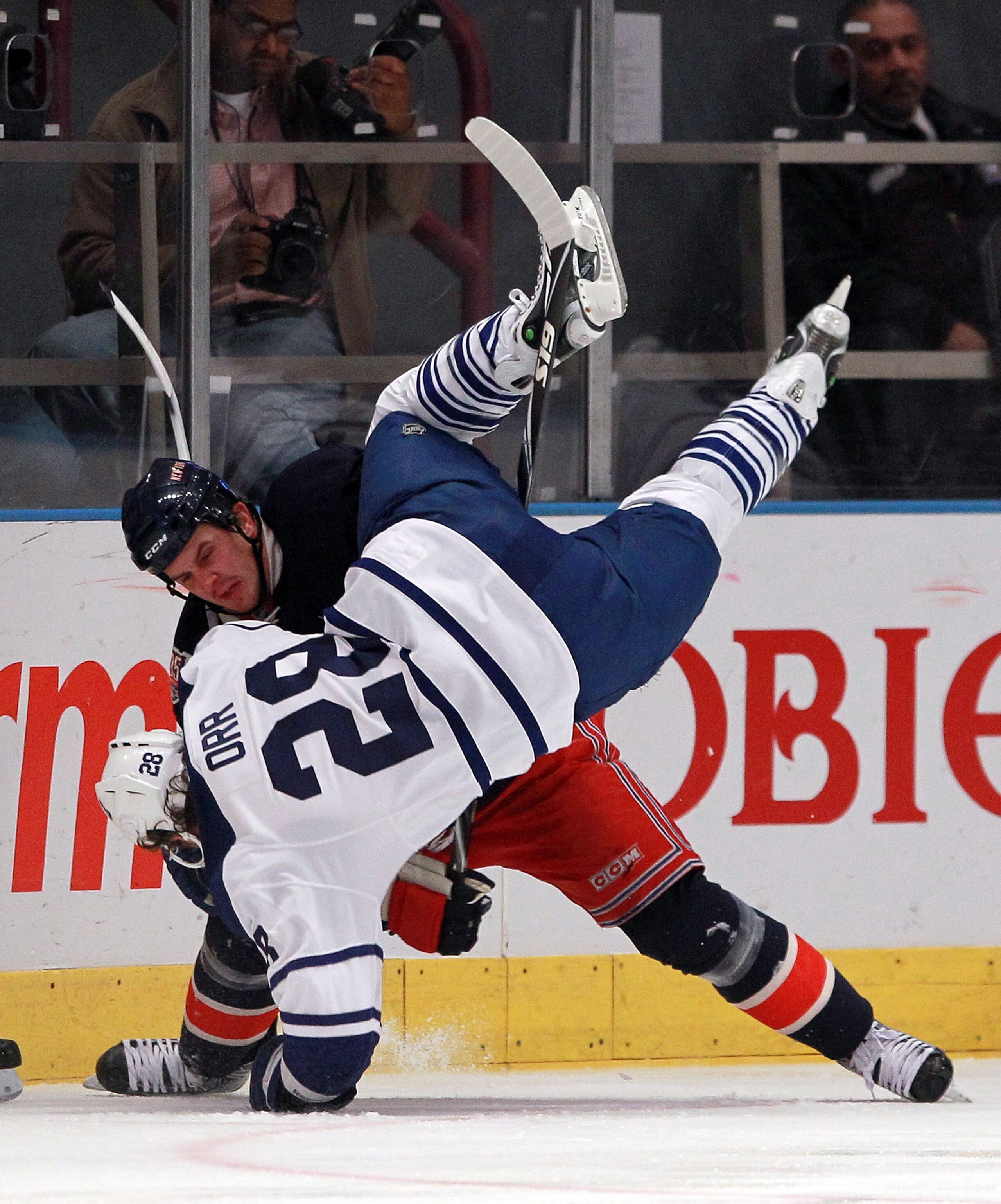 NEW YORK, NY - JANUARY 19:  Colton Orr #28 of the Toronto Maple Leafs is flipped over by Kris Newbury #45 of the New York Rangers during the first period at Madison Square Garden on January 19, 2011 in New York City.  (Photo by Bruce Bennett/Getty Images)