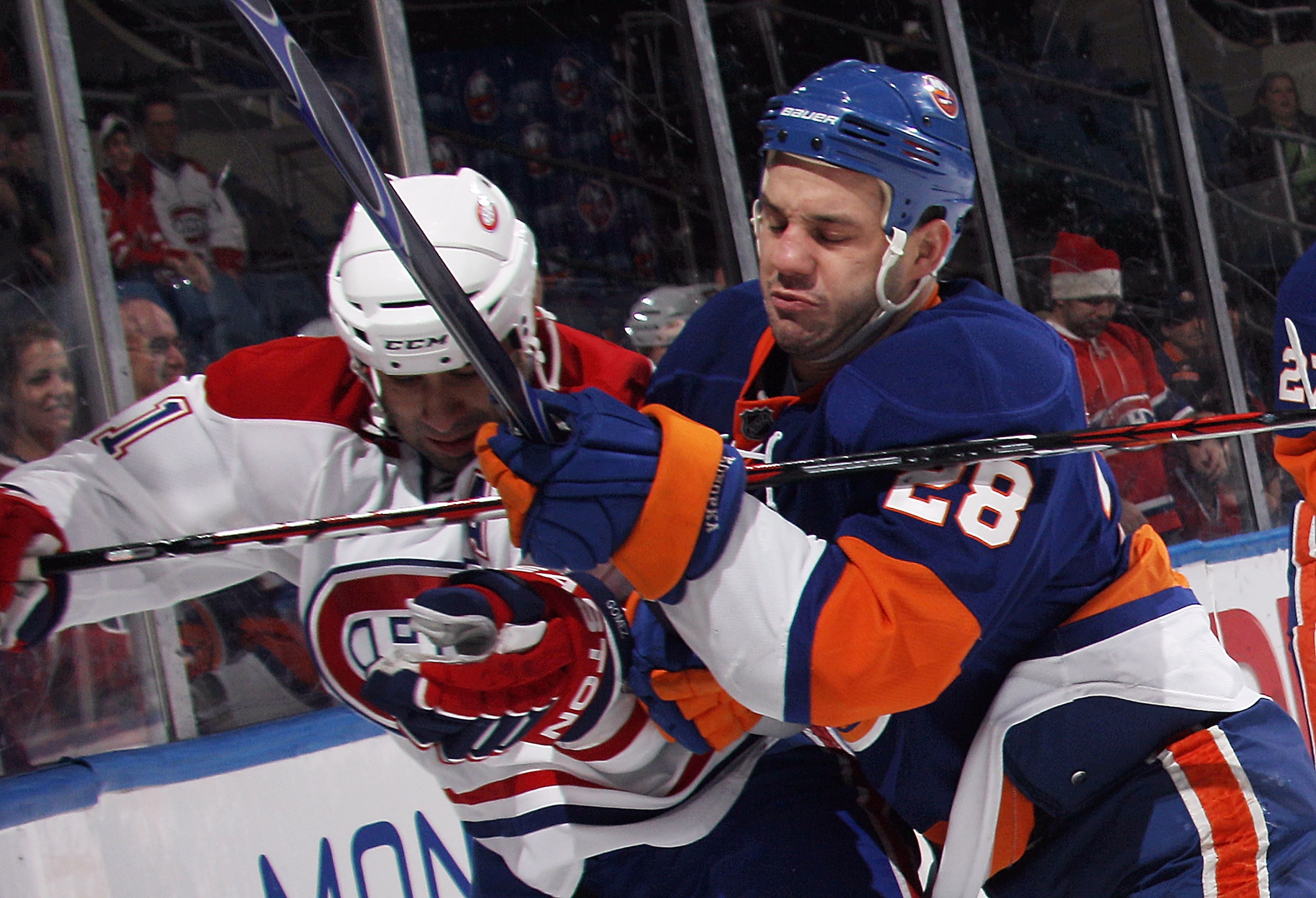 UNIONDALE, NY - DECEMBER 26: Zenon Konopka #28 of the New York Islanders hits Scott Gomez #11 of the Montreal Canadiens at the Nassau Coliseum on December 26, 2010 in Uniondale, New York.  (Photo by Bruce Bennett/Getty Images)